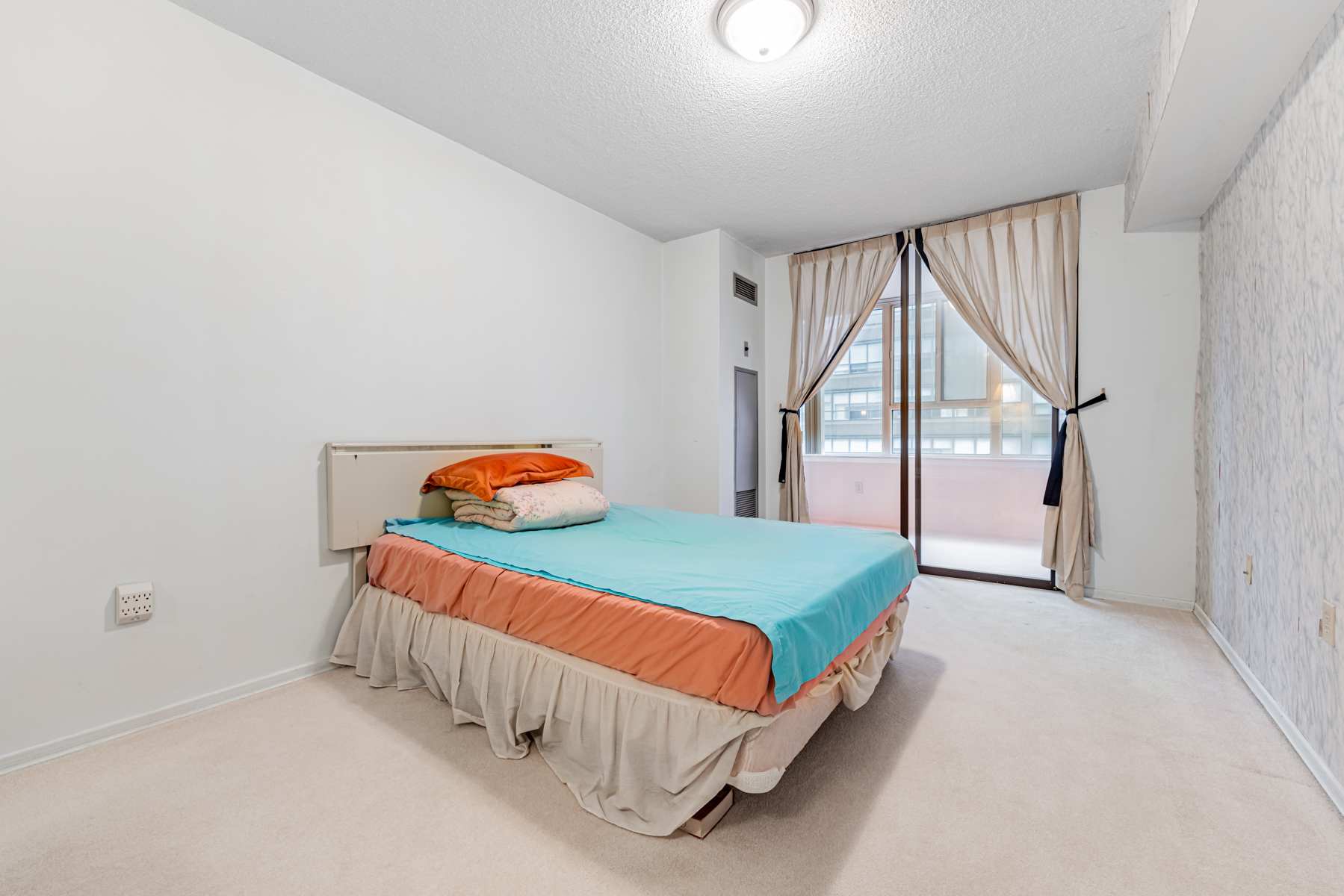 45 Carlton St Unit 1405 large primary bedroom with bed.