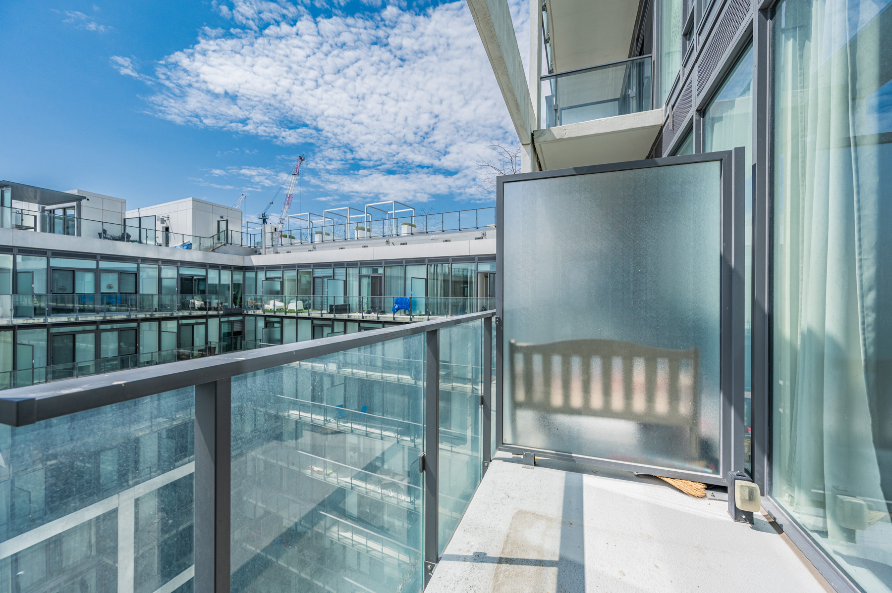 Condo balcony with glazed divider and clear glass panels.