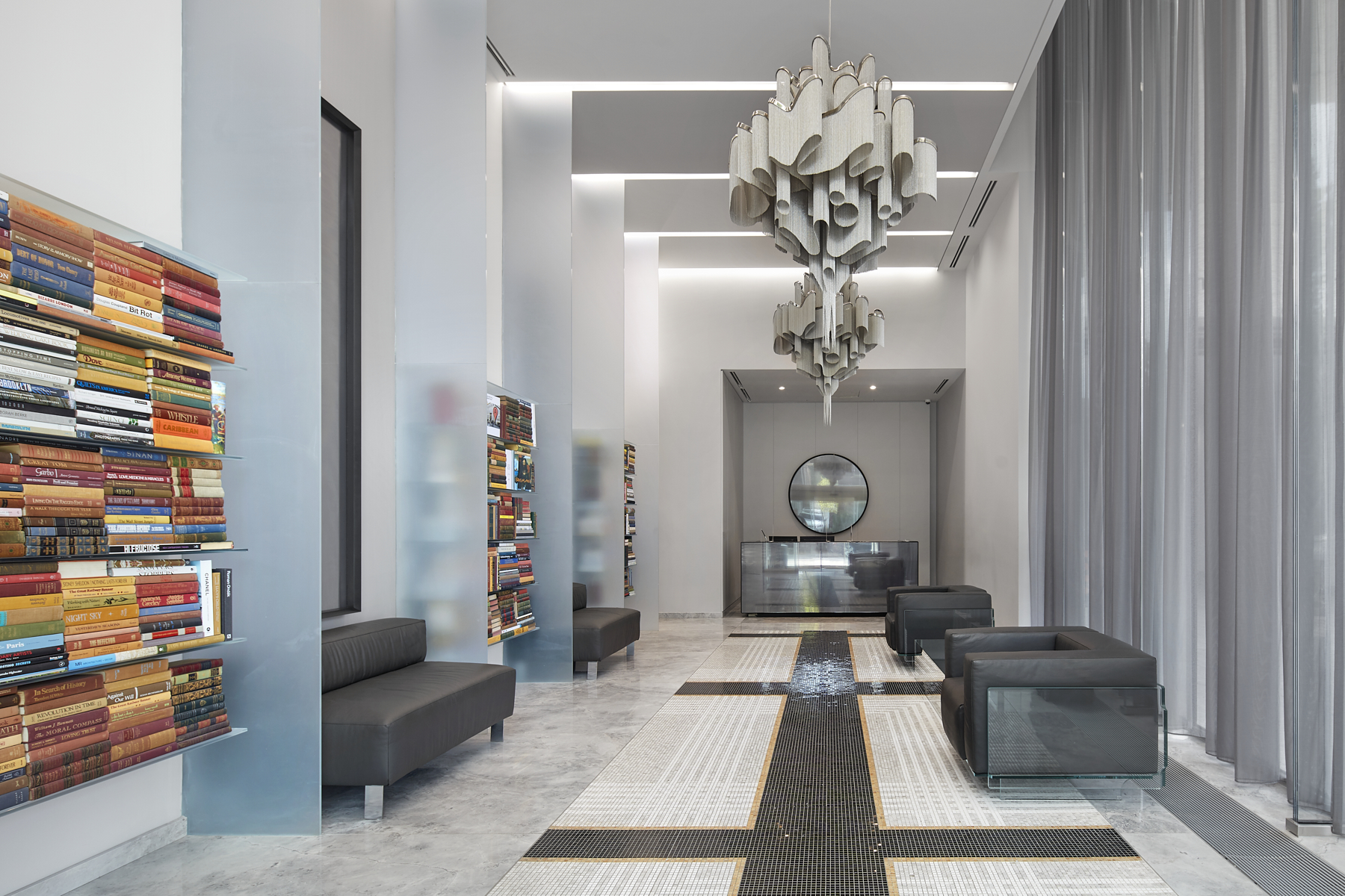 Chic condo lobby with stylish chandelier and bookshelves.
