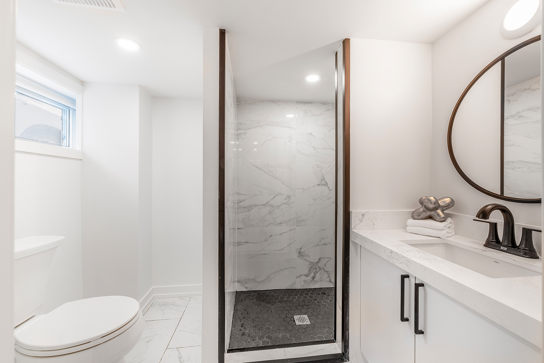 3-piece basement bathroom with walk-in shower, white and gray tiles and oval mirror – 54 Huntington Avenue.