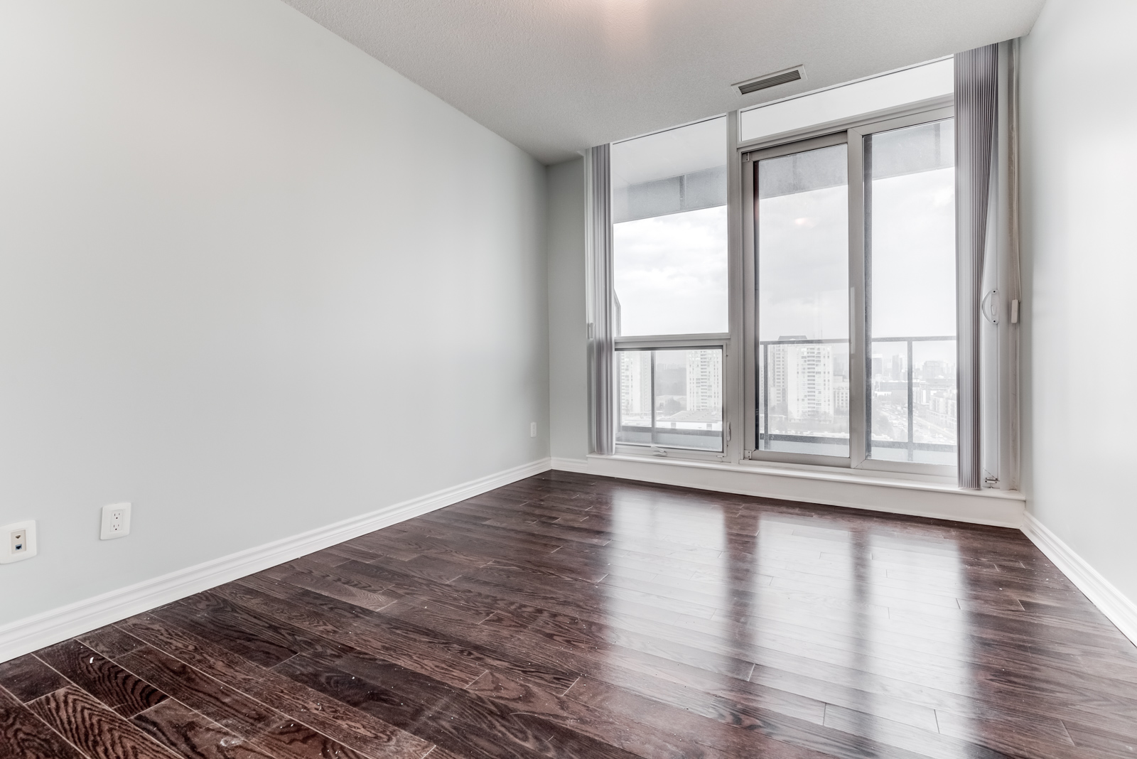 Large primary bedroom with hardwood floors and floor-to-ceiling windows – 2885 Bayview Ave Unit 1106.