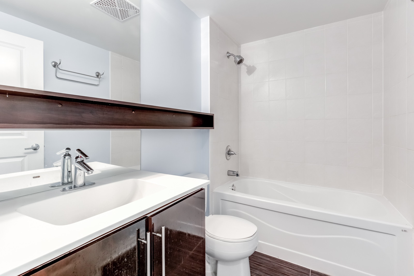 2885 Bayview Ave Unit 1106 bathroom with floating shelves, dual mirrors, under-sink storage, and soaker tub.