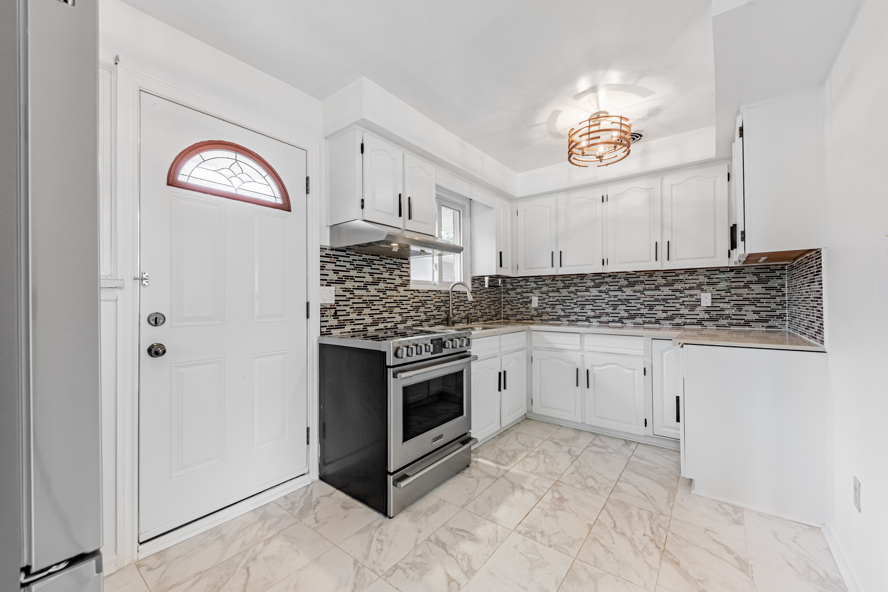 36 Earlton Rd kitchen with porcelain floors, mosaic backsplash, and white cabinets.