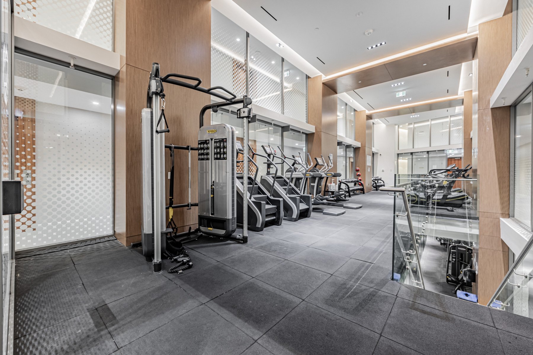 Large condo fitness centre with weights, Stair Master, treadmill and other equipment.