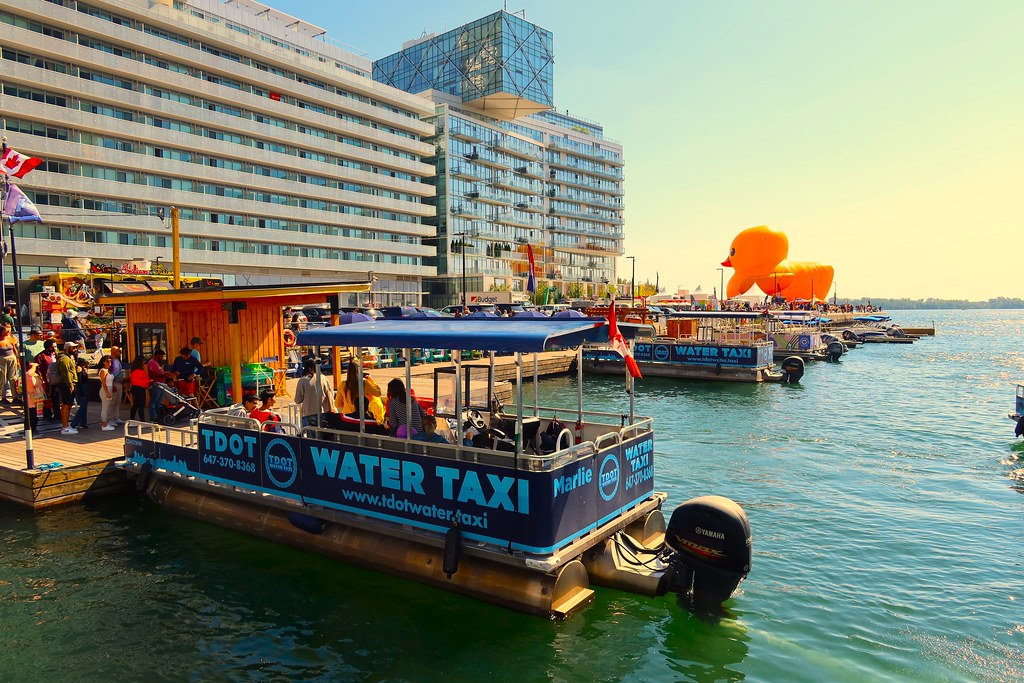 Crowd around water taxi on pier close to 15 Queens Quay E. 