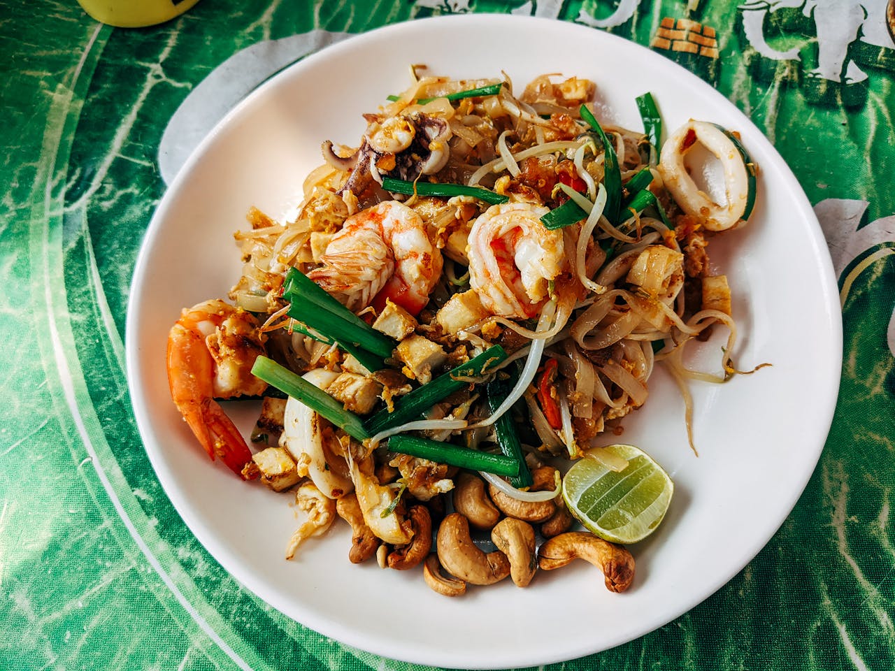 Plate of pad Thai with shrimp and vegetables. 