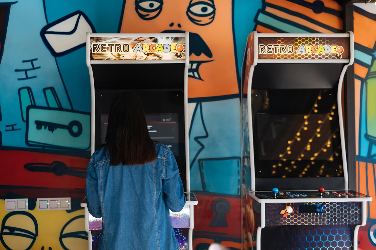 Woman playing an arcade game with her back to viewer.