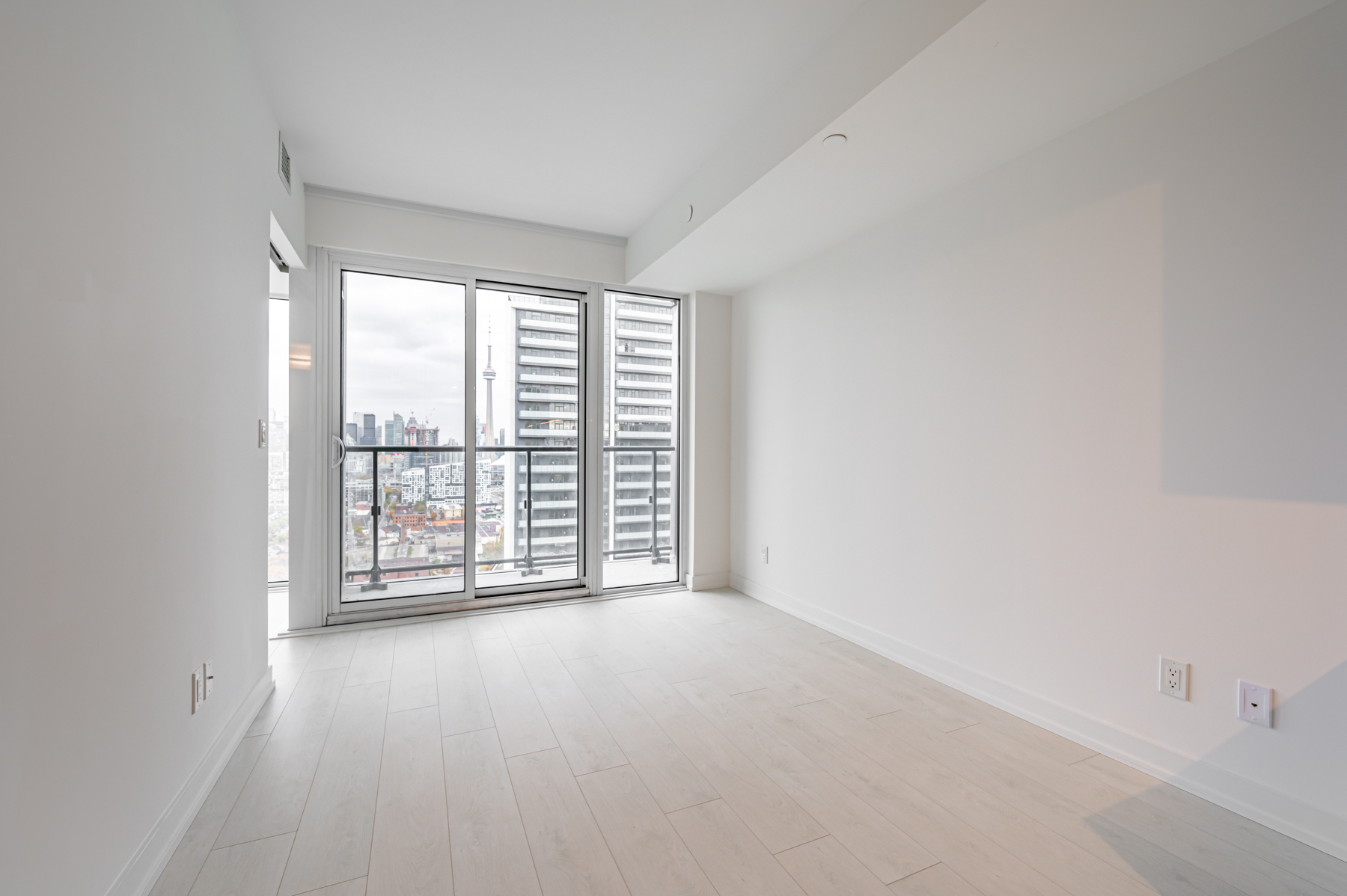 Condo living room with light coloured laminate floors.