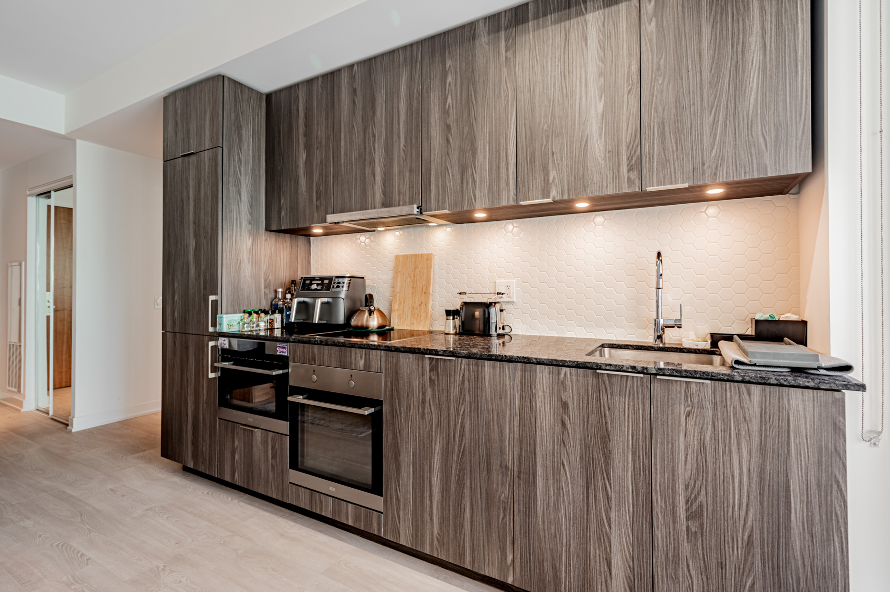 Closeup of kitchen back-splash with honeycomb design and under-cabinet lights.