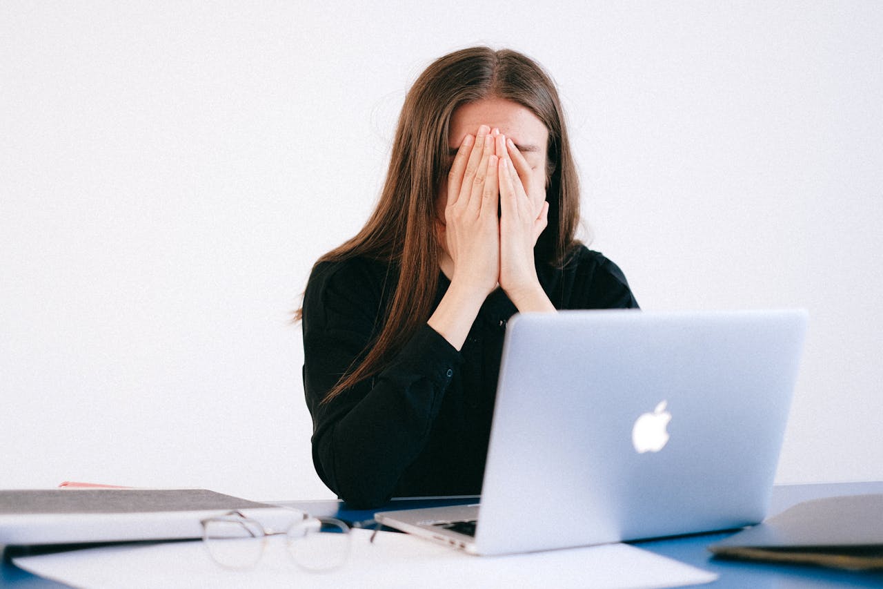 Photo of stressed young woman covering face with hands to show impact of 2nd rate cut on mortgages.