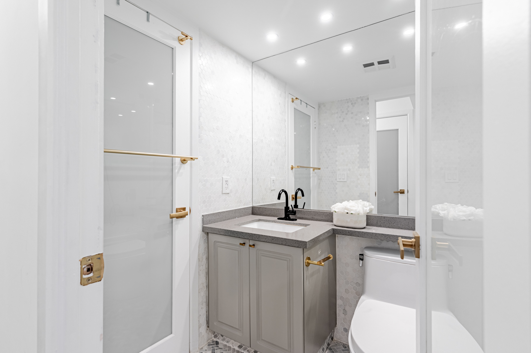 Beautiful condo bathroom with built-in vanity and large mirror.