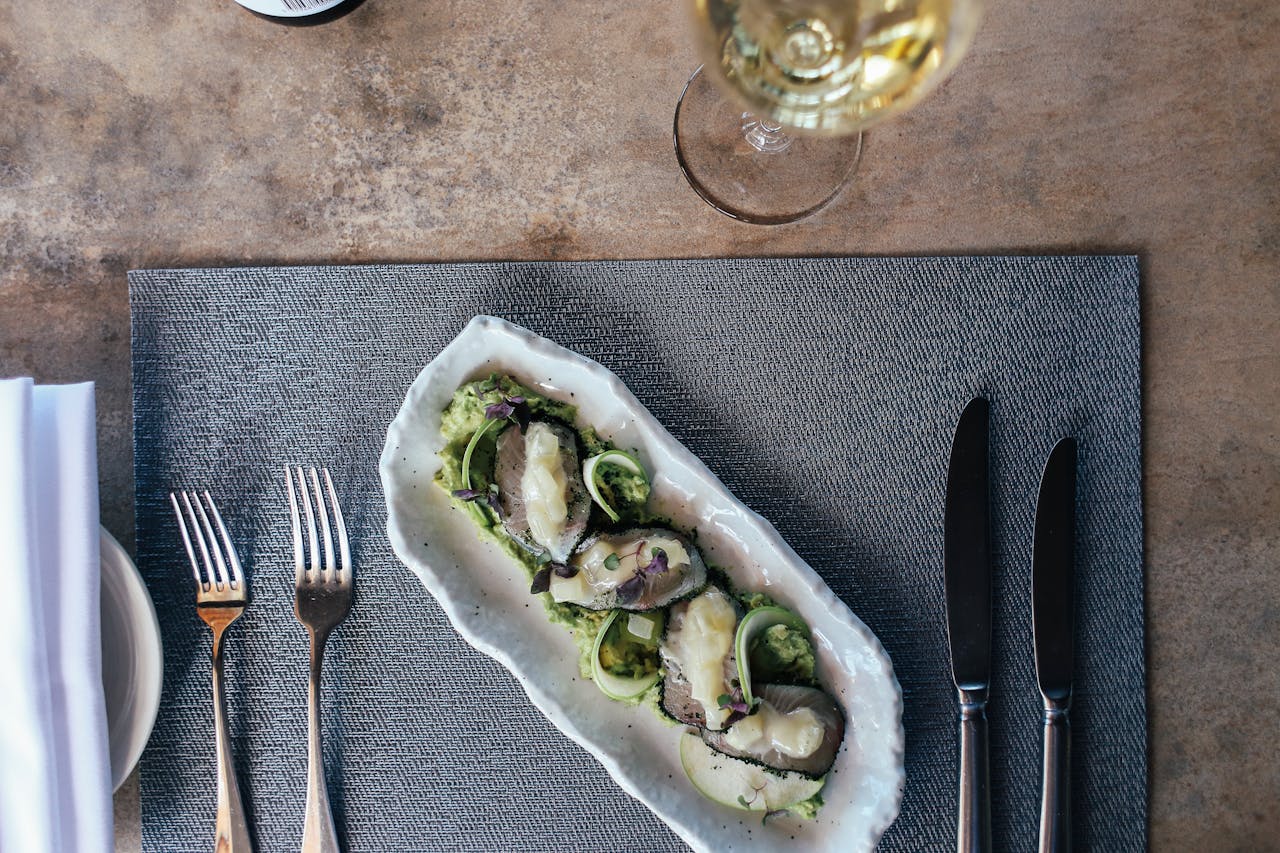 Oysters in white plate placed on gray napkin. 