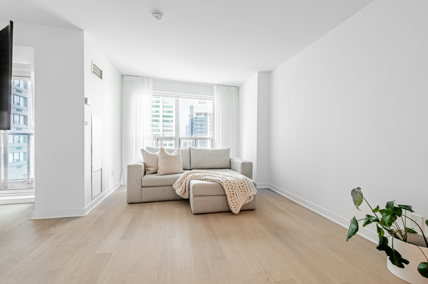 Renovated condo living room with hardwood floors and newly painted walls.