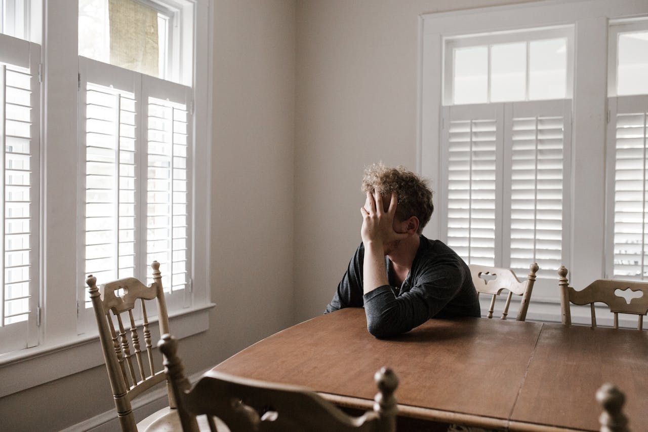 Photo of stressed man in dining room to show GTA home seller struggles in August 2024.