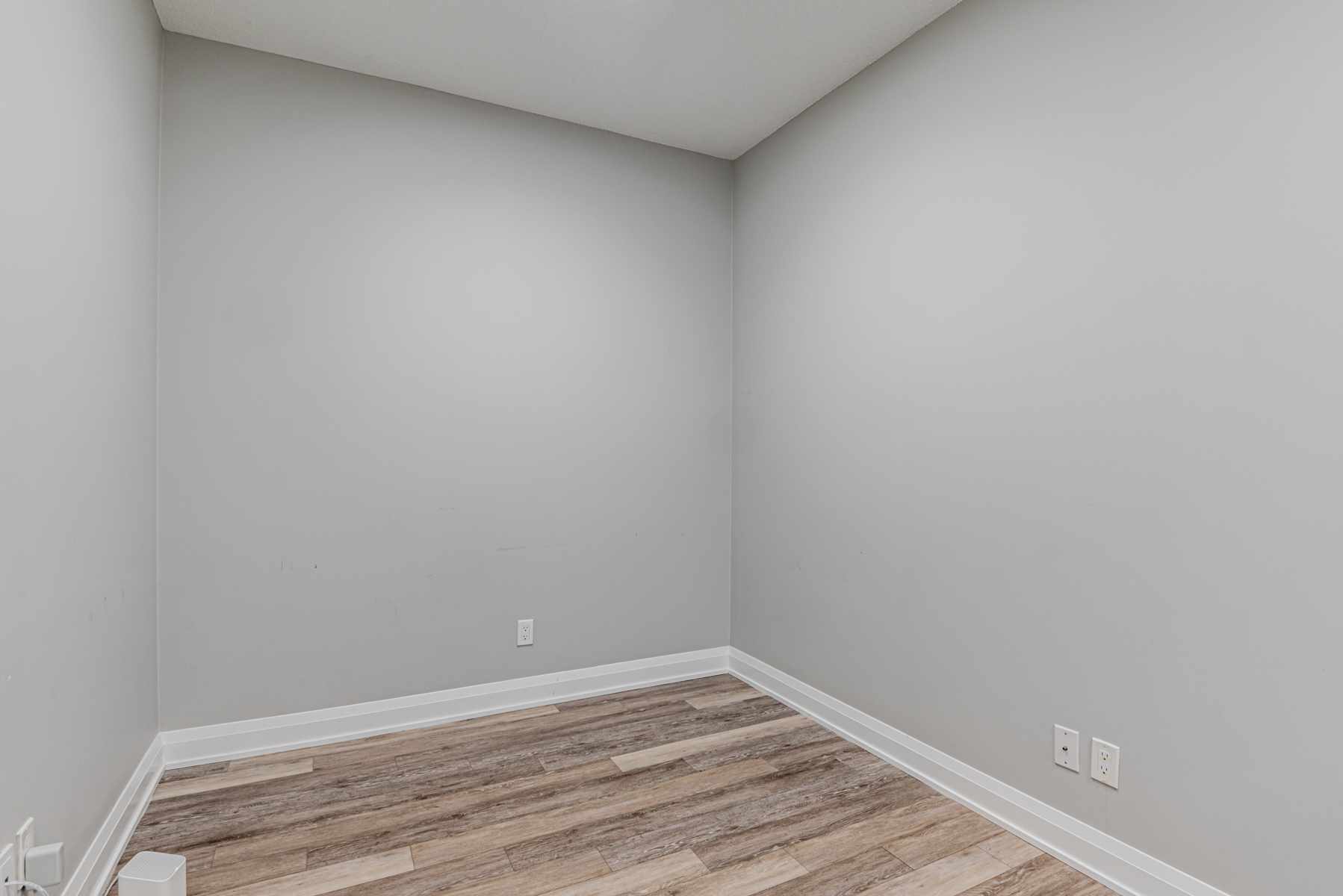 Empty condo den with gray walls and vinyl floors – 15 Water Walk Dr Suite 711.