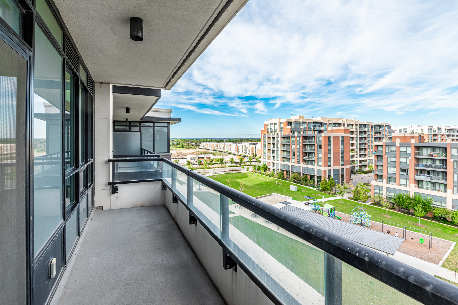 15 Water Walk Dr Unit 711 balcony with glass panels and view of park.