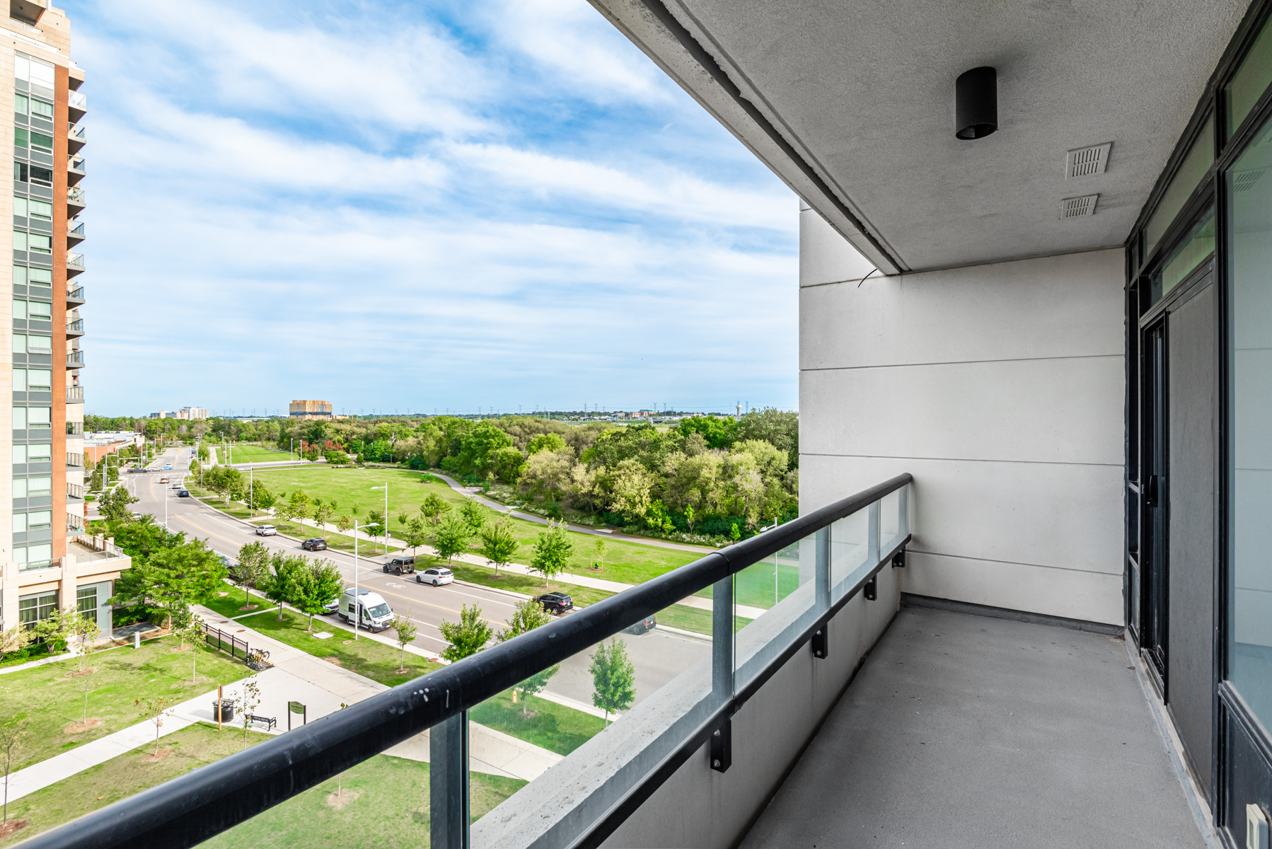 Condo balcony with glass panels and side wall.