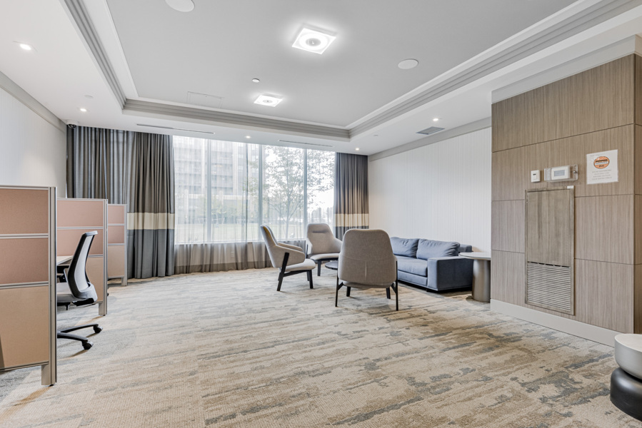 Riverside Condos workroom amenity with cubicles and sofas.