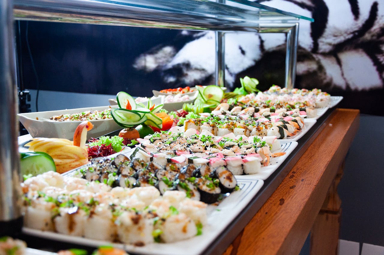 Sushi on white plates on brown wooden table. 