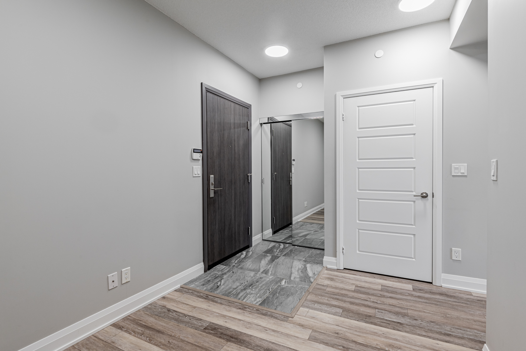 15 Water Walk Dr Unit 711 foyer with dark gray porcelain tiles and mirror door closet.