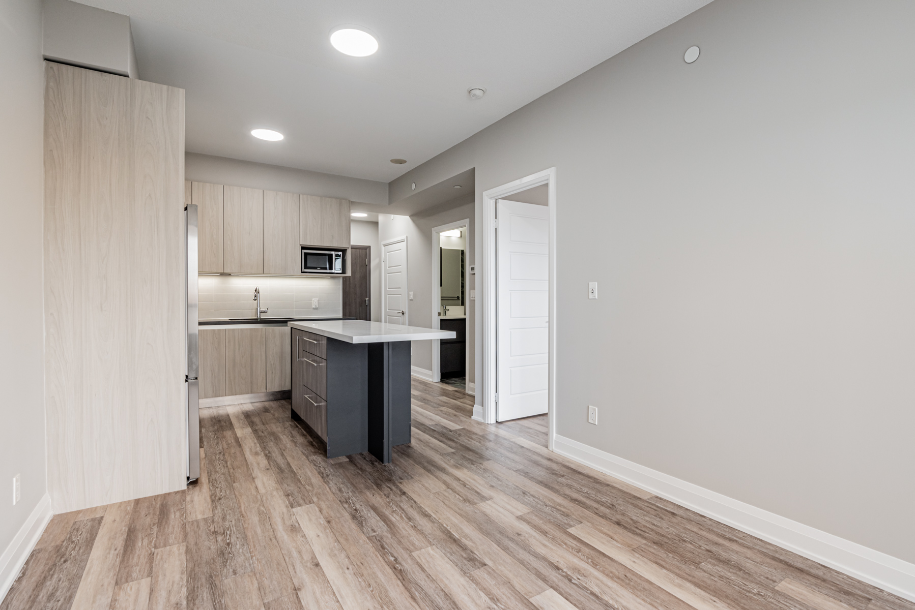 Dark wood-like vinyl flooring in 15 Water Walk Dr Unit 711 living room, dining room and kitchen.