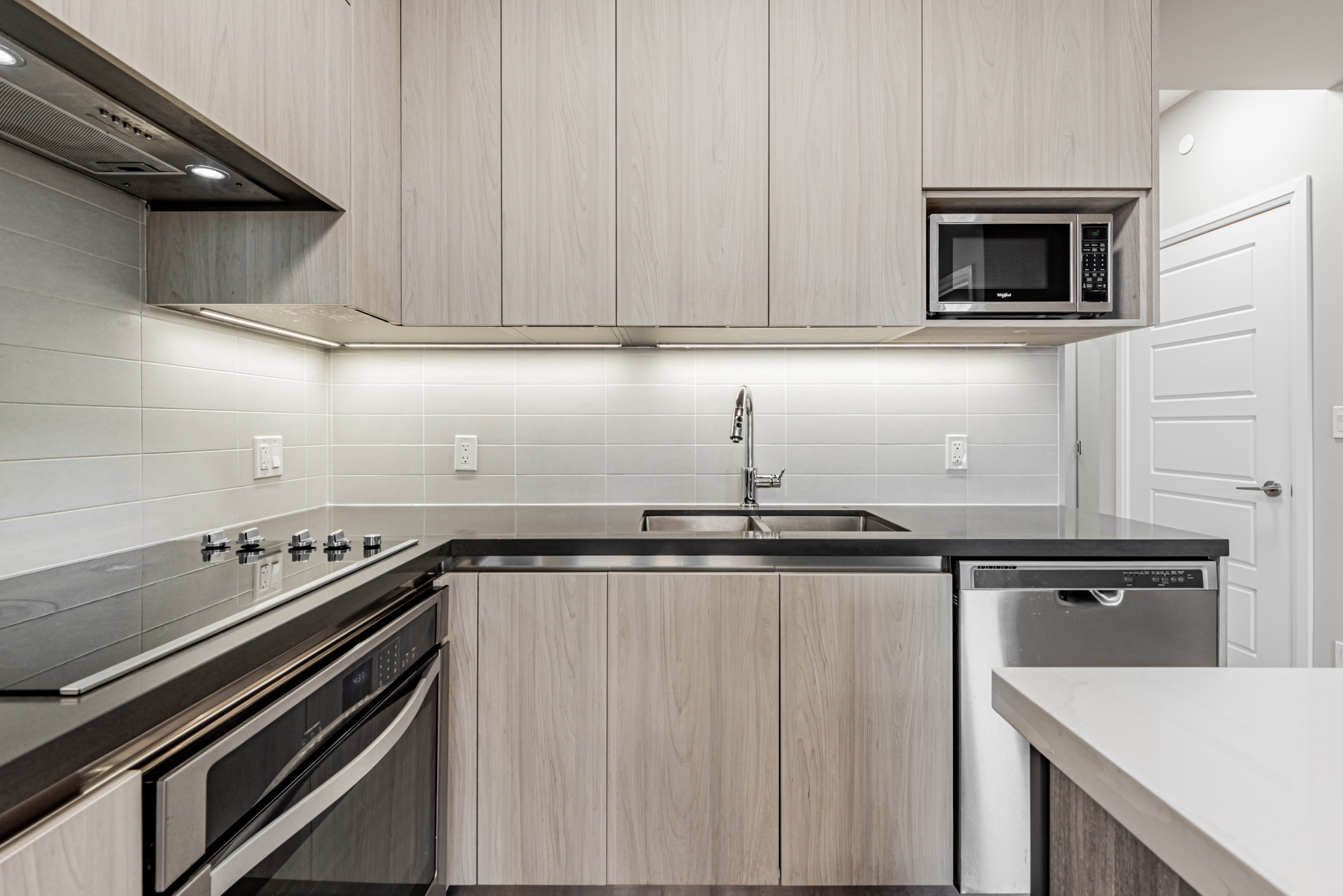 Condo kitchen with under-cabinet lights.