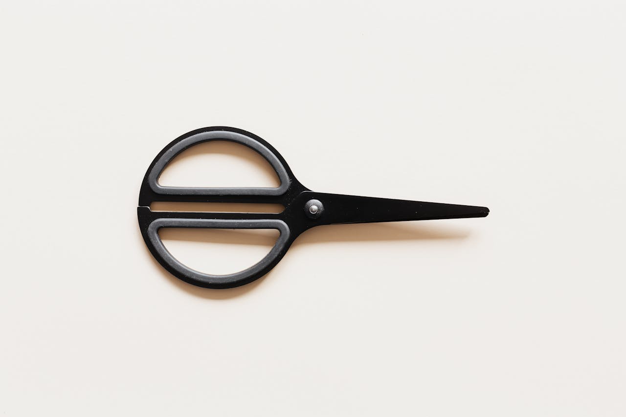 Scissors on beige background to show impact of rate cuts. 