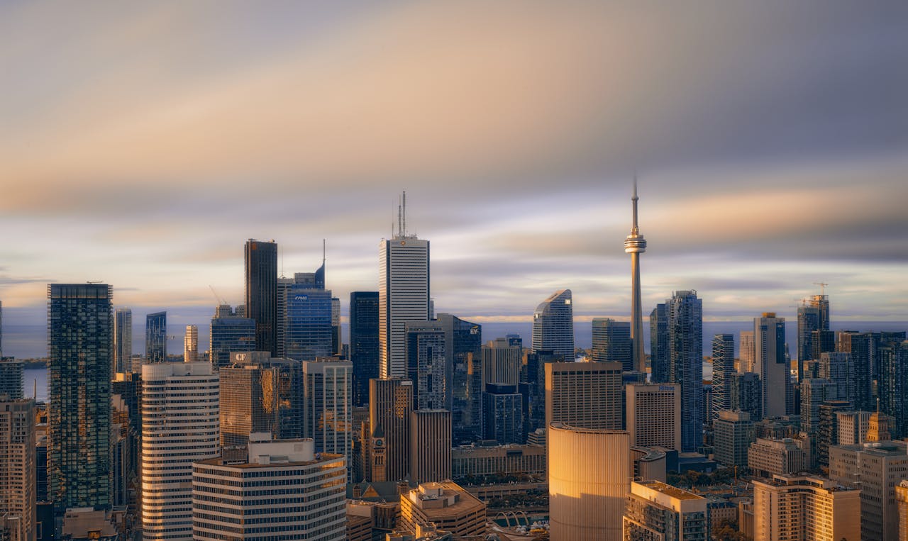 Photo of Toronto skyline with buildings, CN Tower, clouds. 