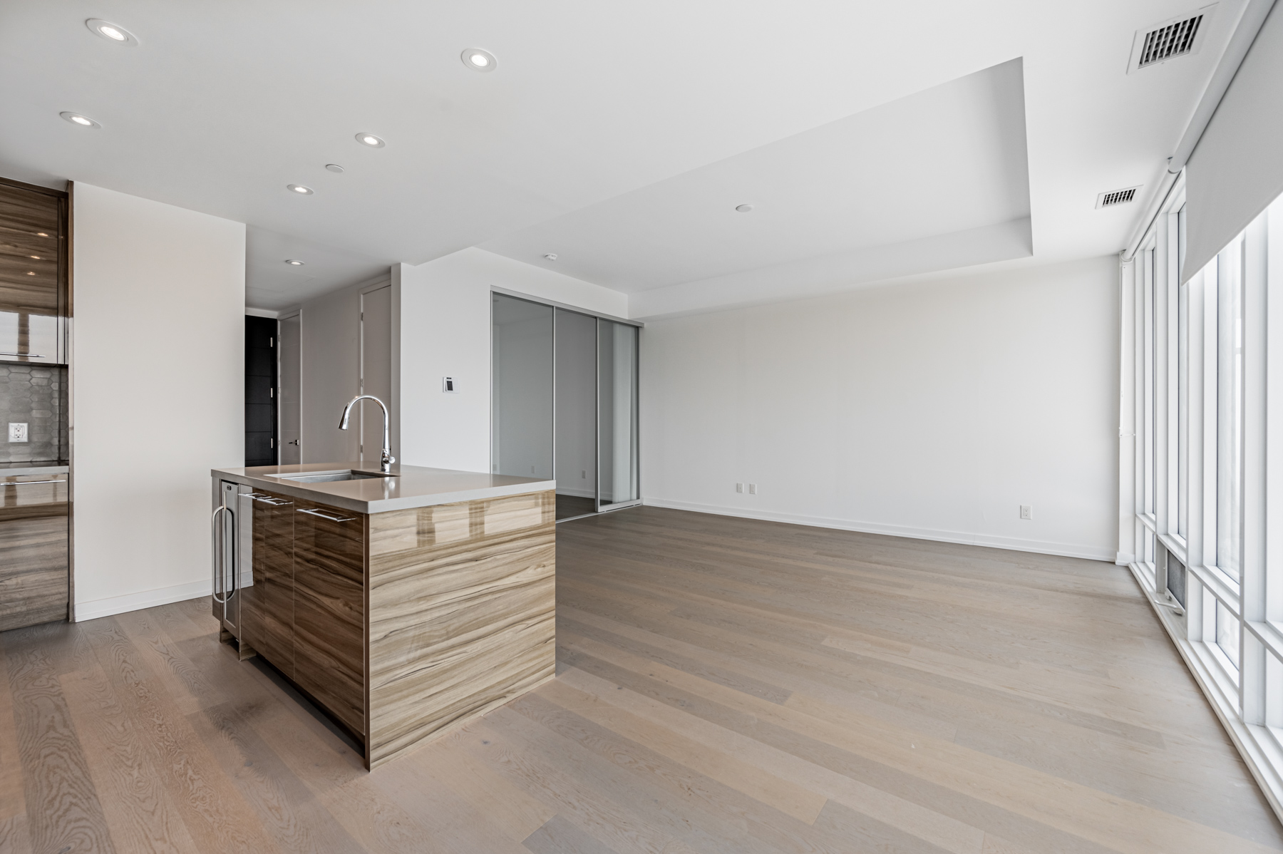 Condo kitchen island with white counters and glossy brown sides.