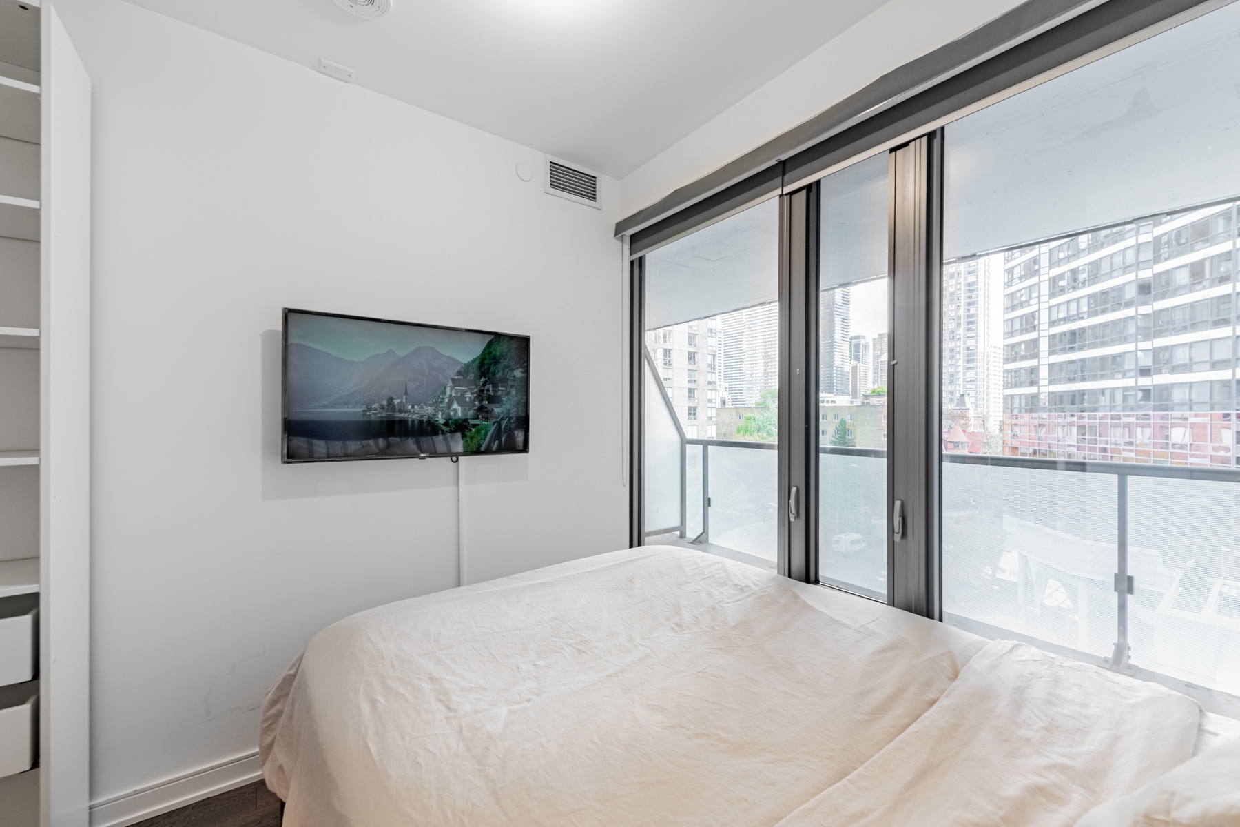 Condo primary bedroom with large glass windows.