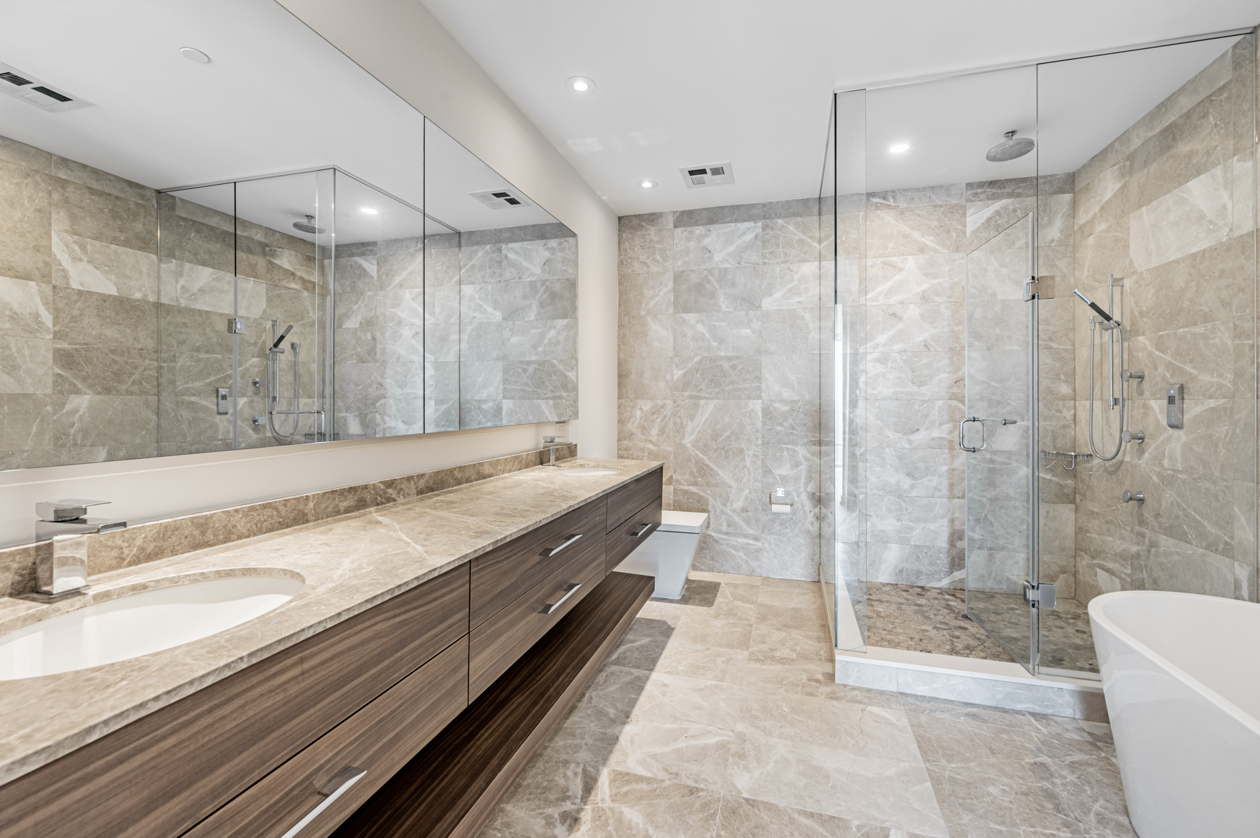 488 University Ave Suite 5408 ensuite bath with two sinks and natural stone tiles.