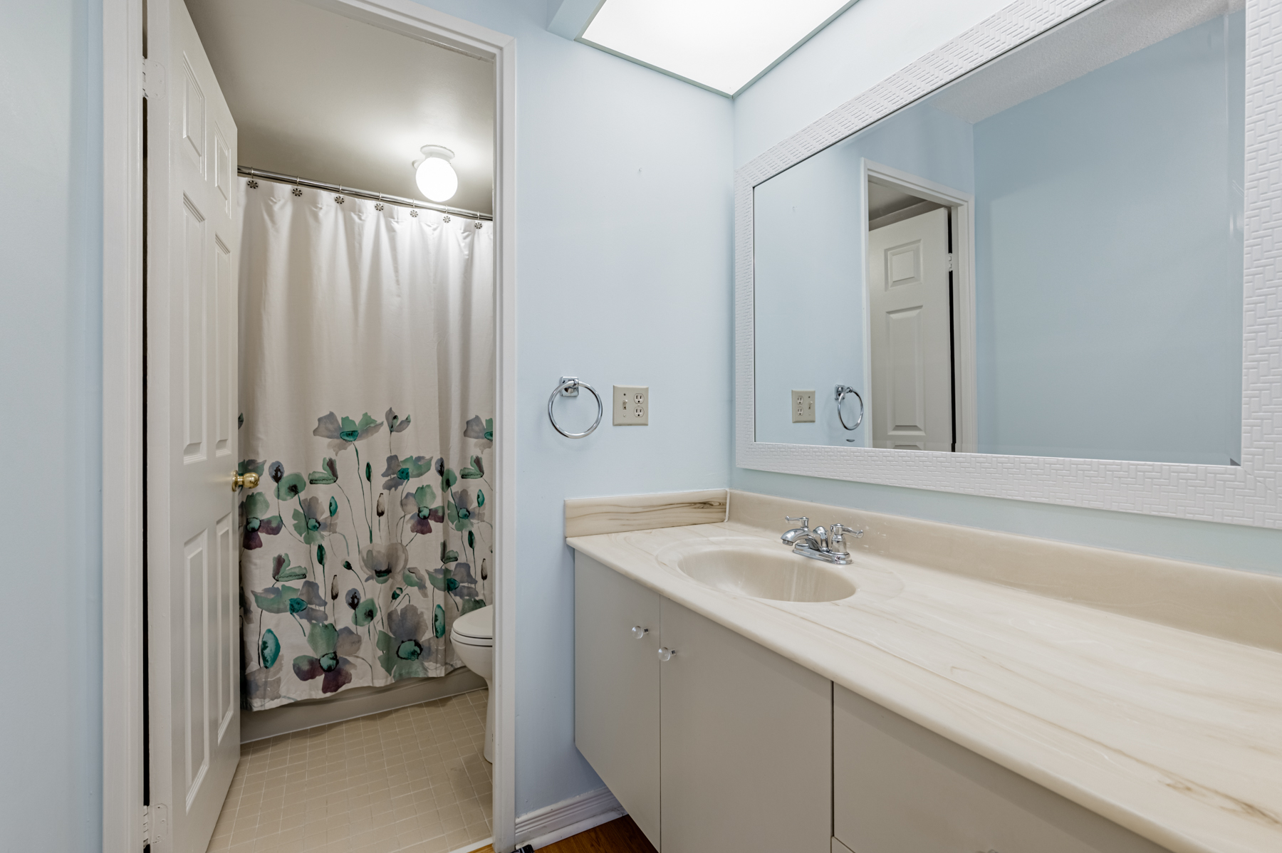 4-piece ensuite bath with a floating vanity and large mirror – 280 Simcoe St 308A.