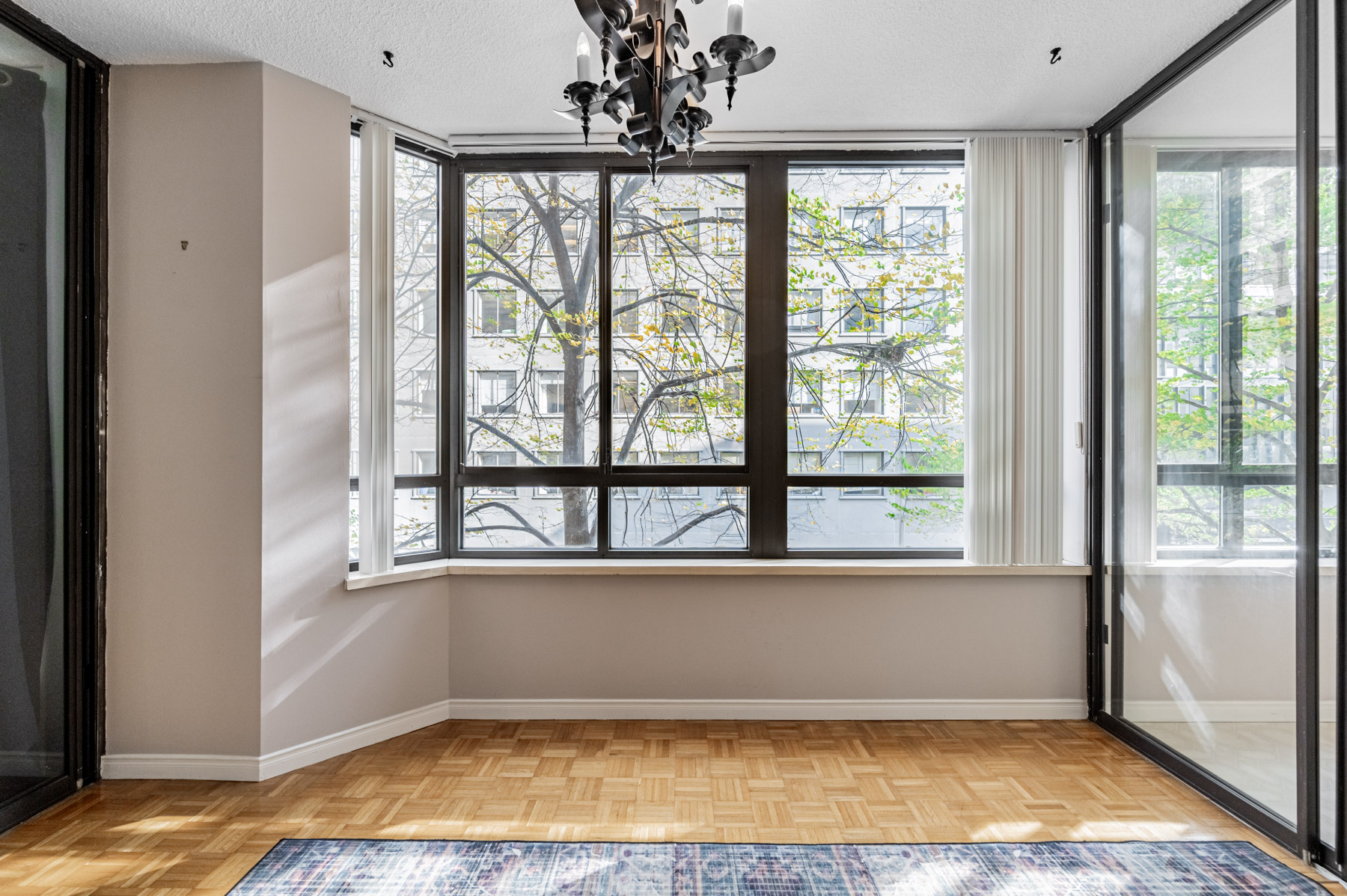 280 Simcoe St 308A solarium with large windows showing view of trees and buildings. 