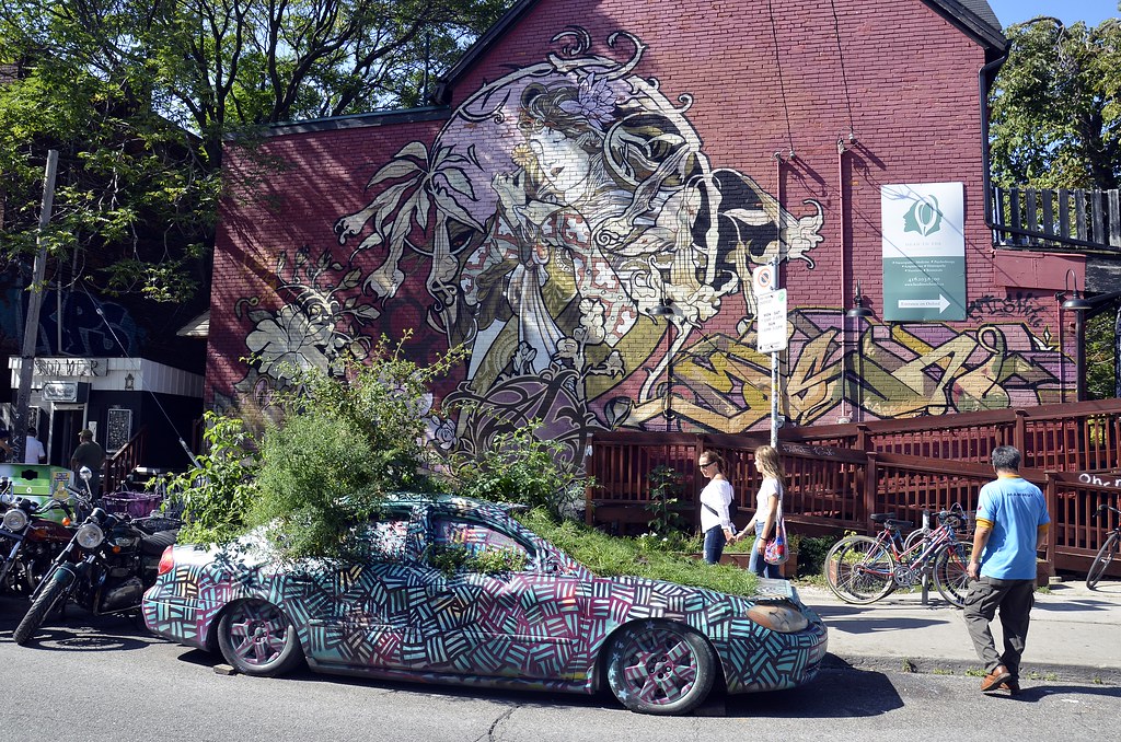 Colourful mural on wall of red-brick building in Toronto's Kensington-Chinatown neighbourhood. 