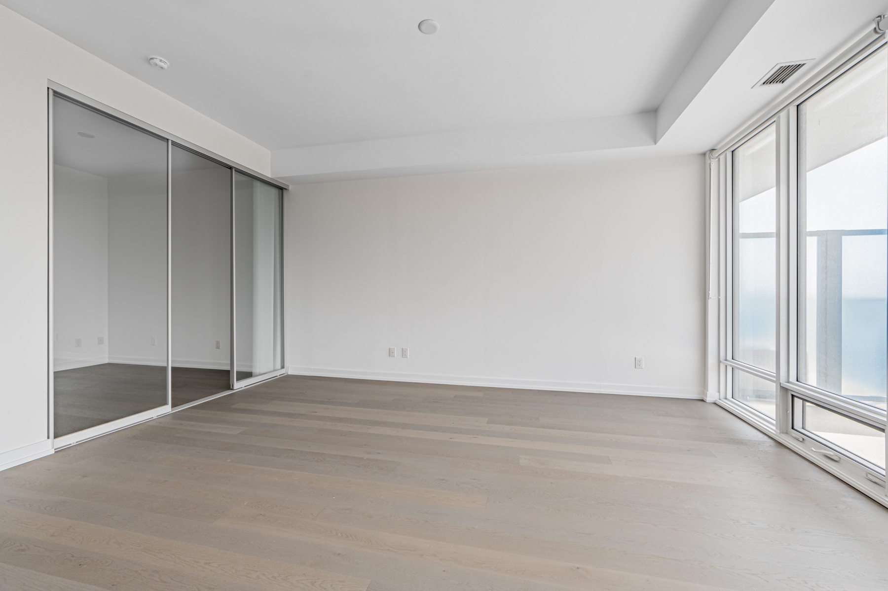 Condo living room with hardwood floors and gray walls.