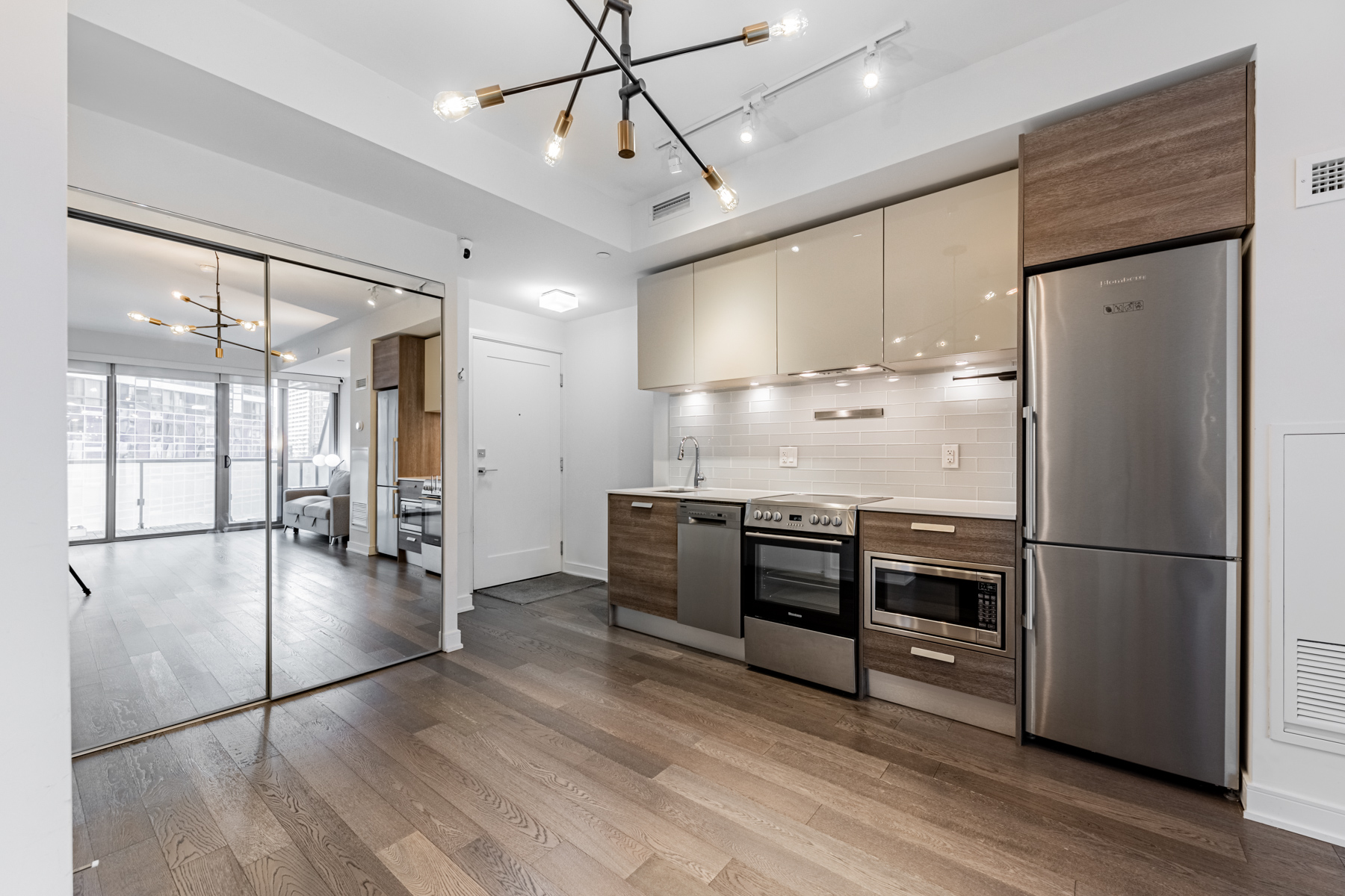 Condo kitchen and dining area with large mirror-door closet.