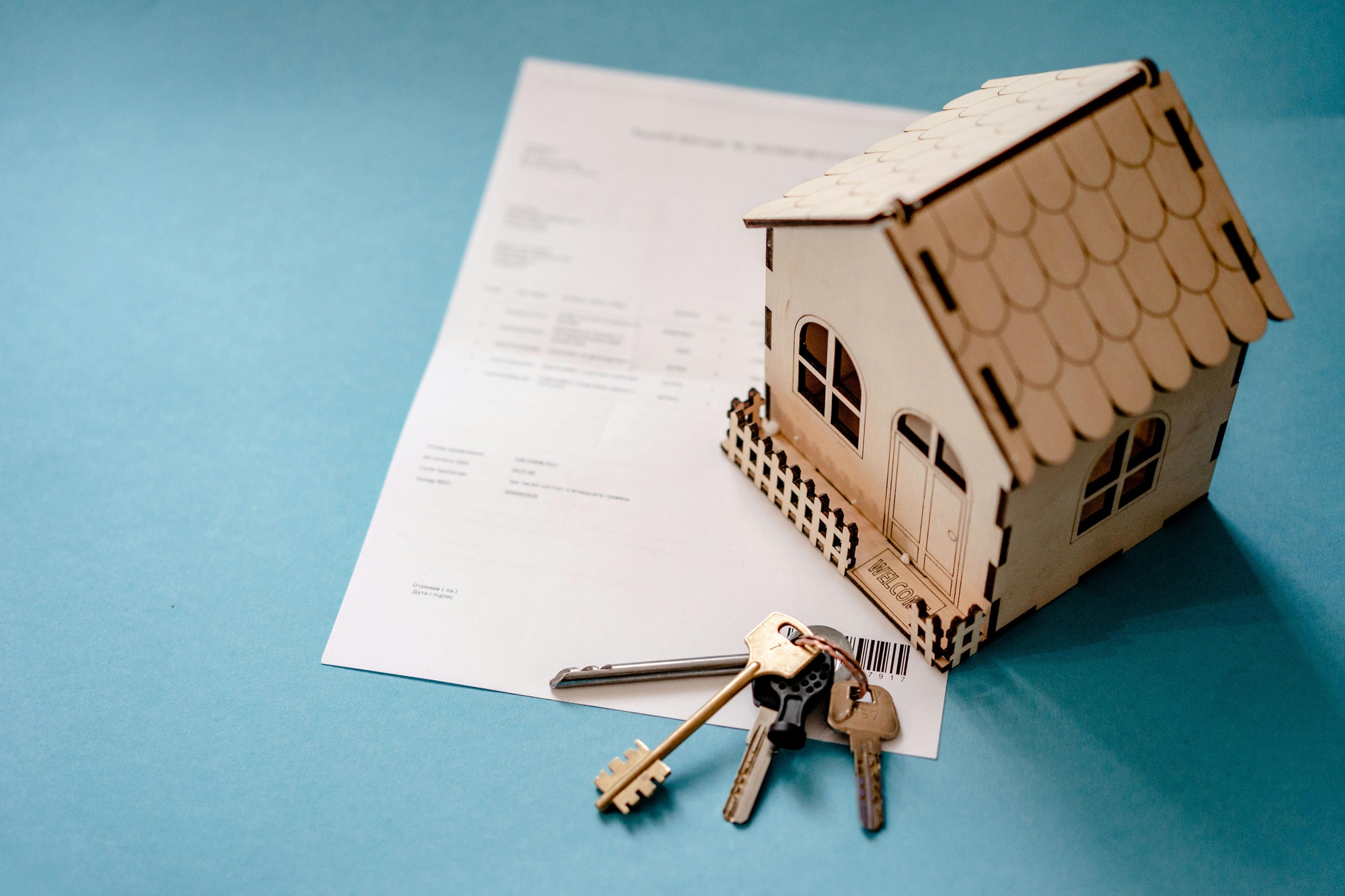 Image of toy house with keys and paper.