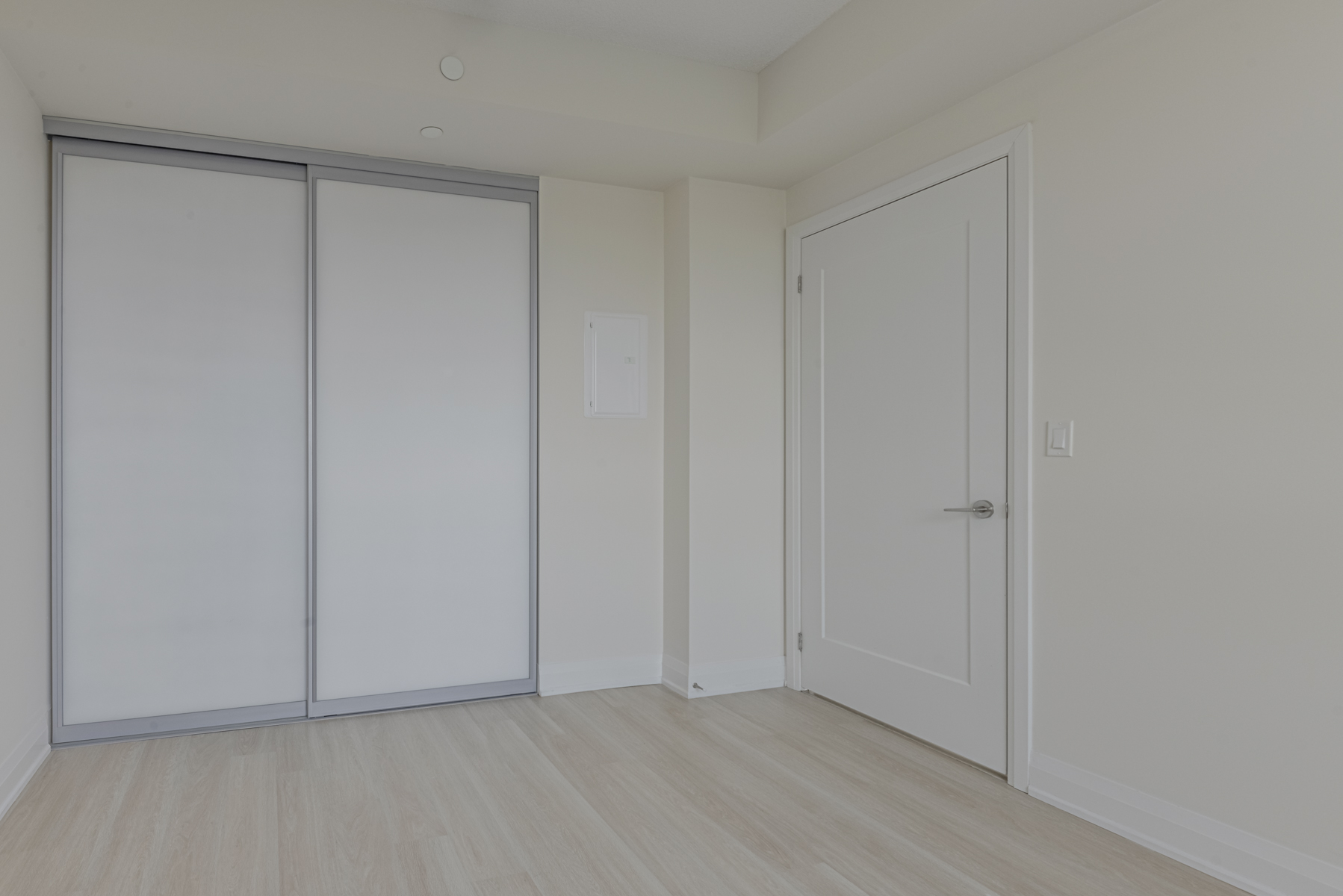 Condo bedroom with sliding double-door closet.