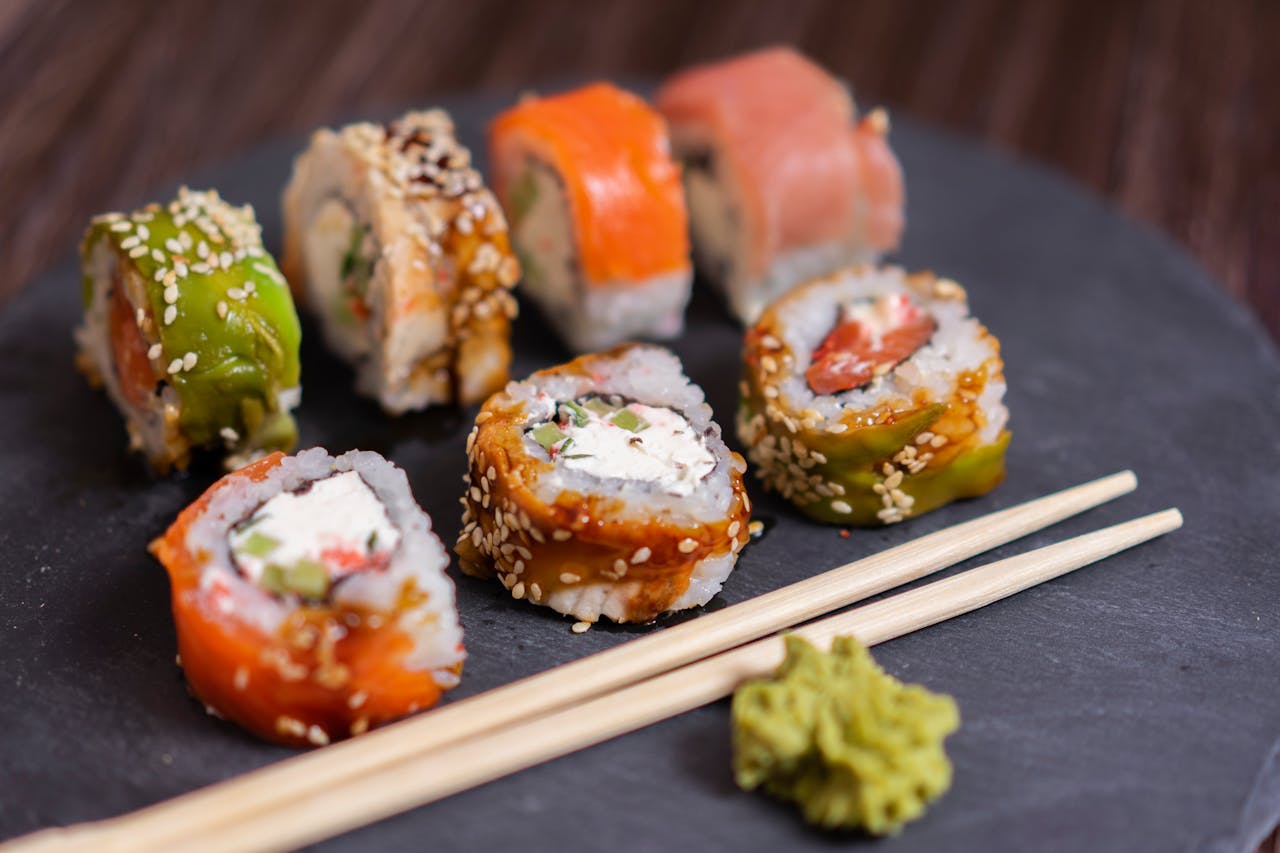 Plate of colourful sushi with chopsticks.