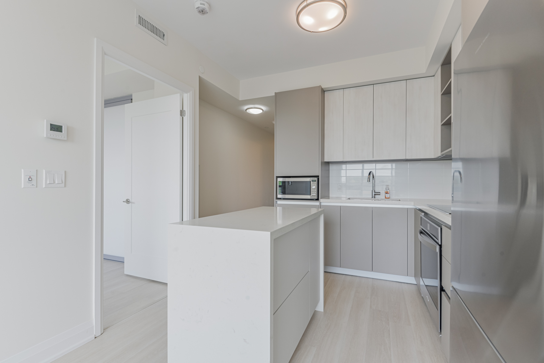 Photo of light-toned condo kitchen.