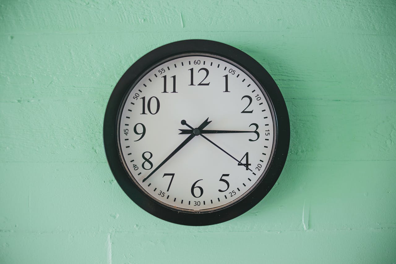 Analog clock on green wall to show importance of timing in January 2025 market. 