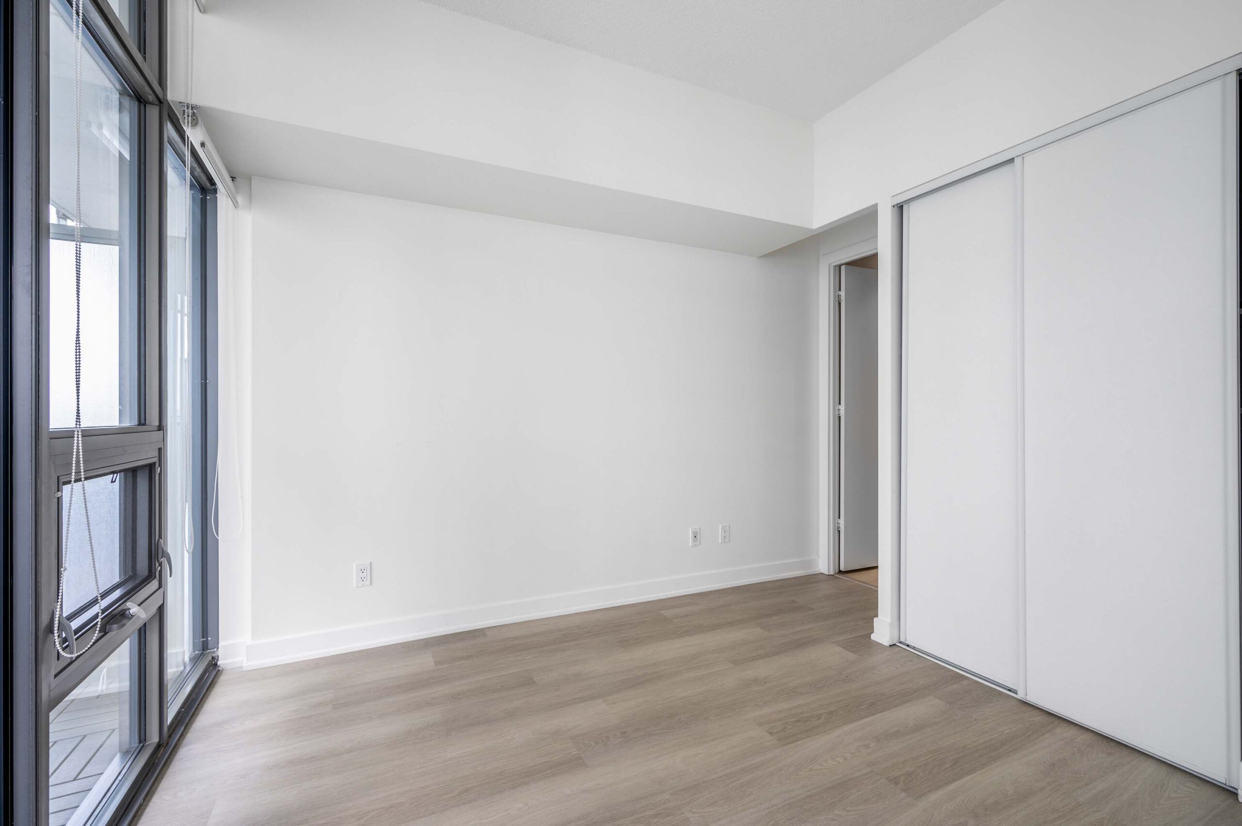 33 Charles St E Unit 3808 primary bedroom with vinyl floors and balcony.