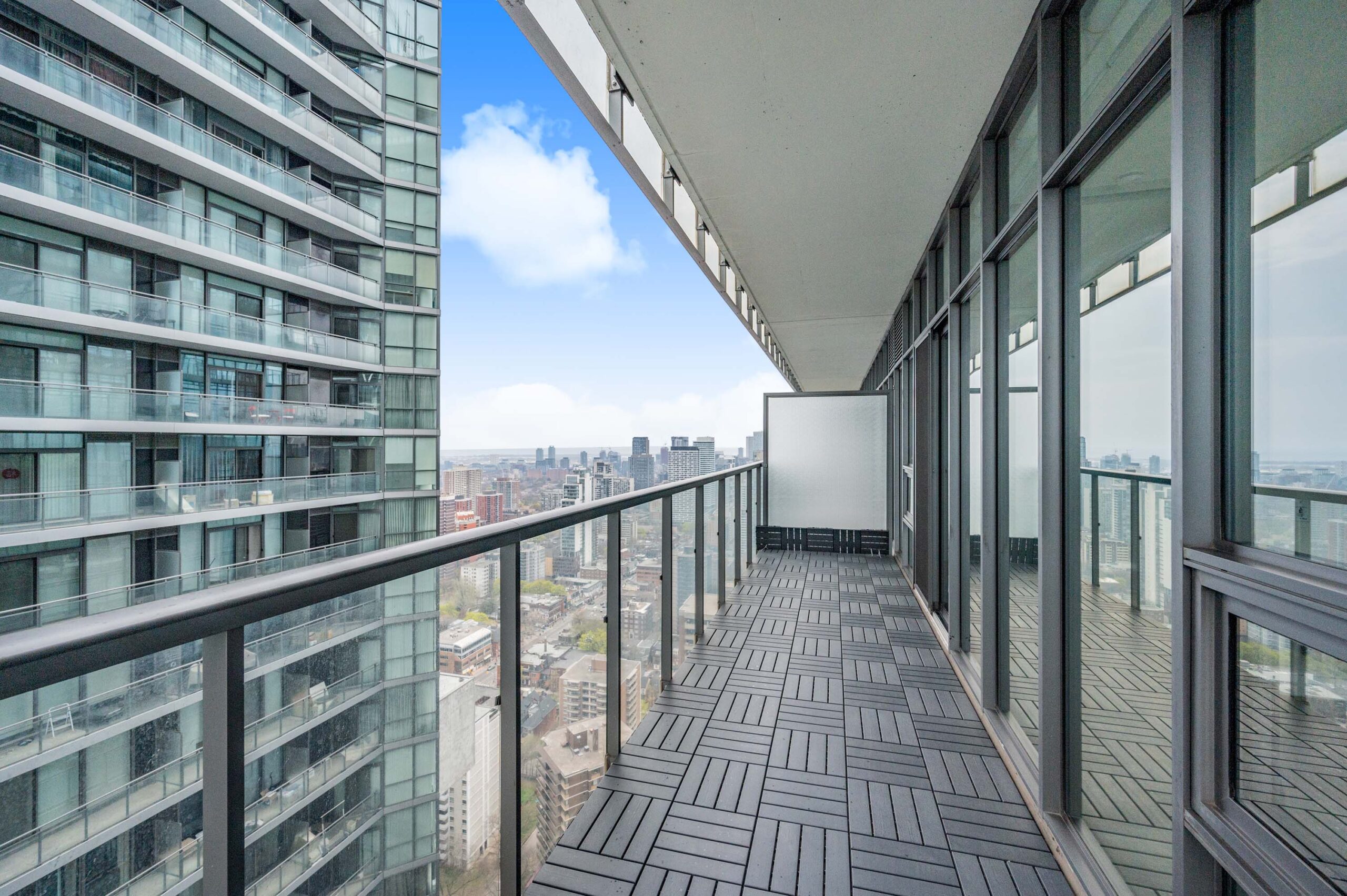 Condo balcony with dark floor tiles.