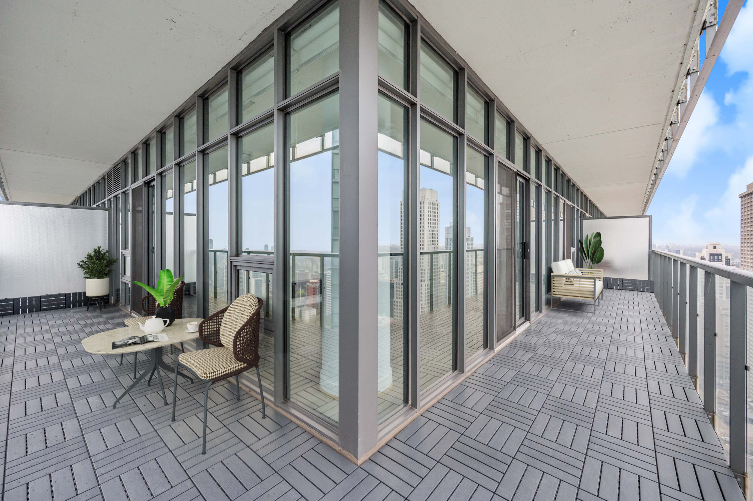 Wrap-around condo balcony with patio furniture.