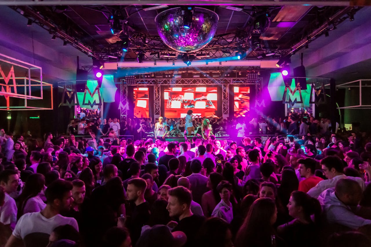 People dancing at club with purplish lighting.