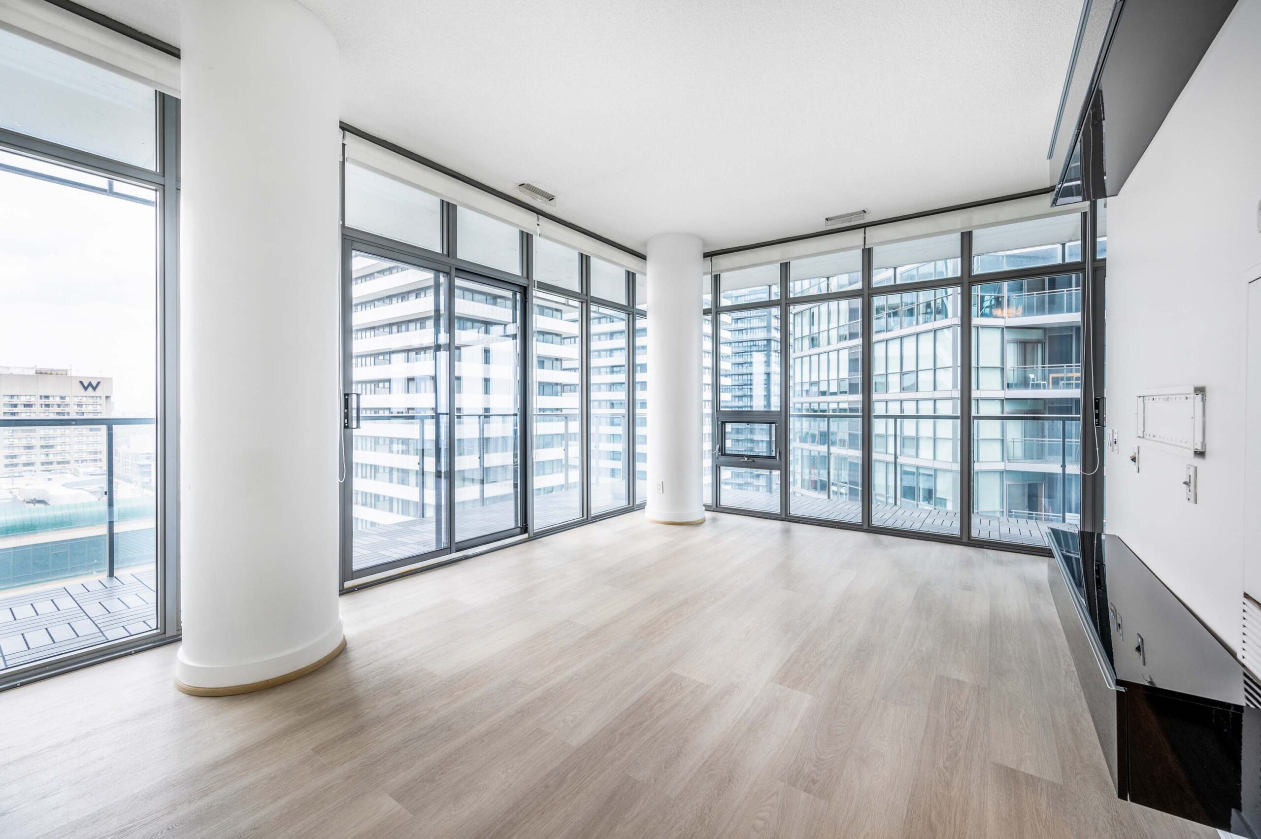 Condo with floor-to-ceiling, wall-to-wall windows showing Toronto skyline.