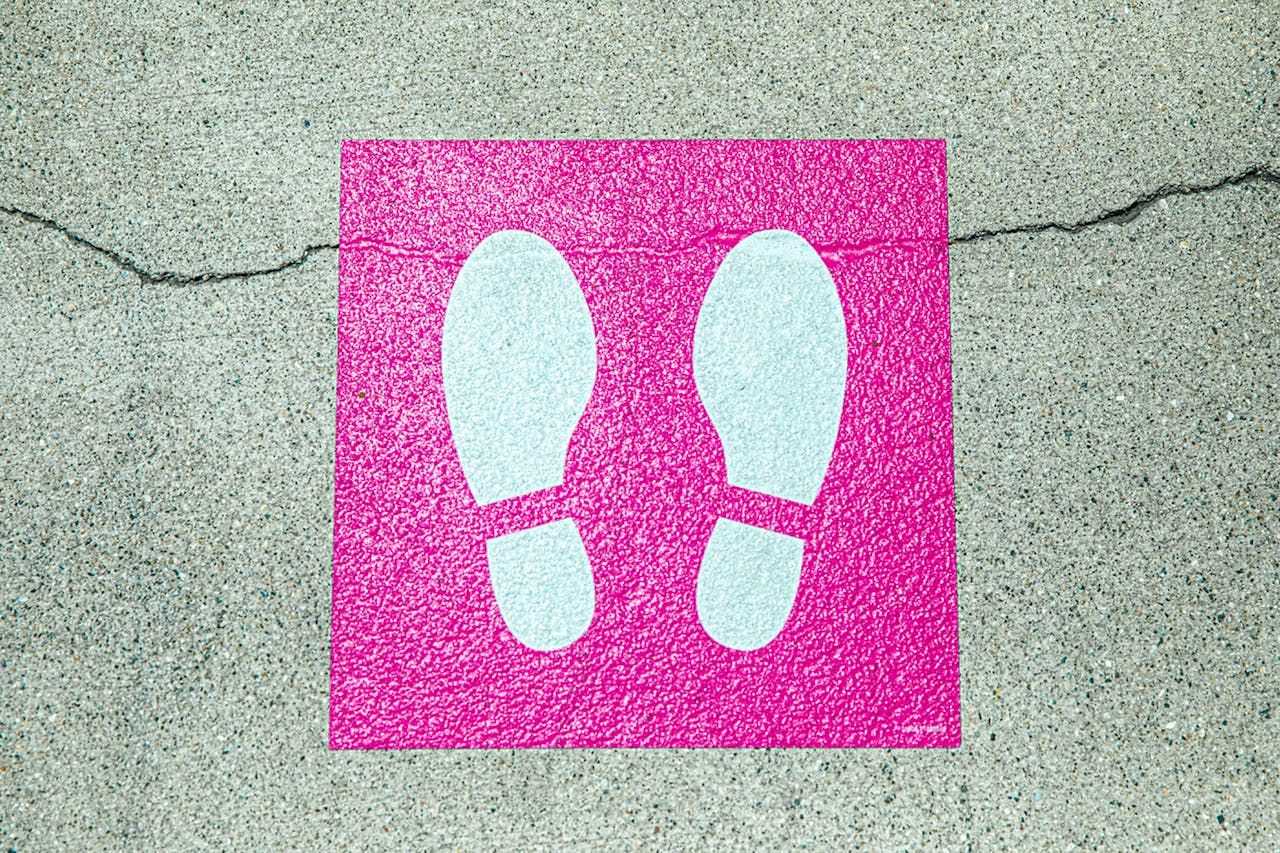 Photo of painted pink and white sign on road to symbolize guide to buying resale property.