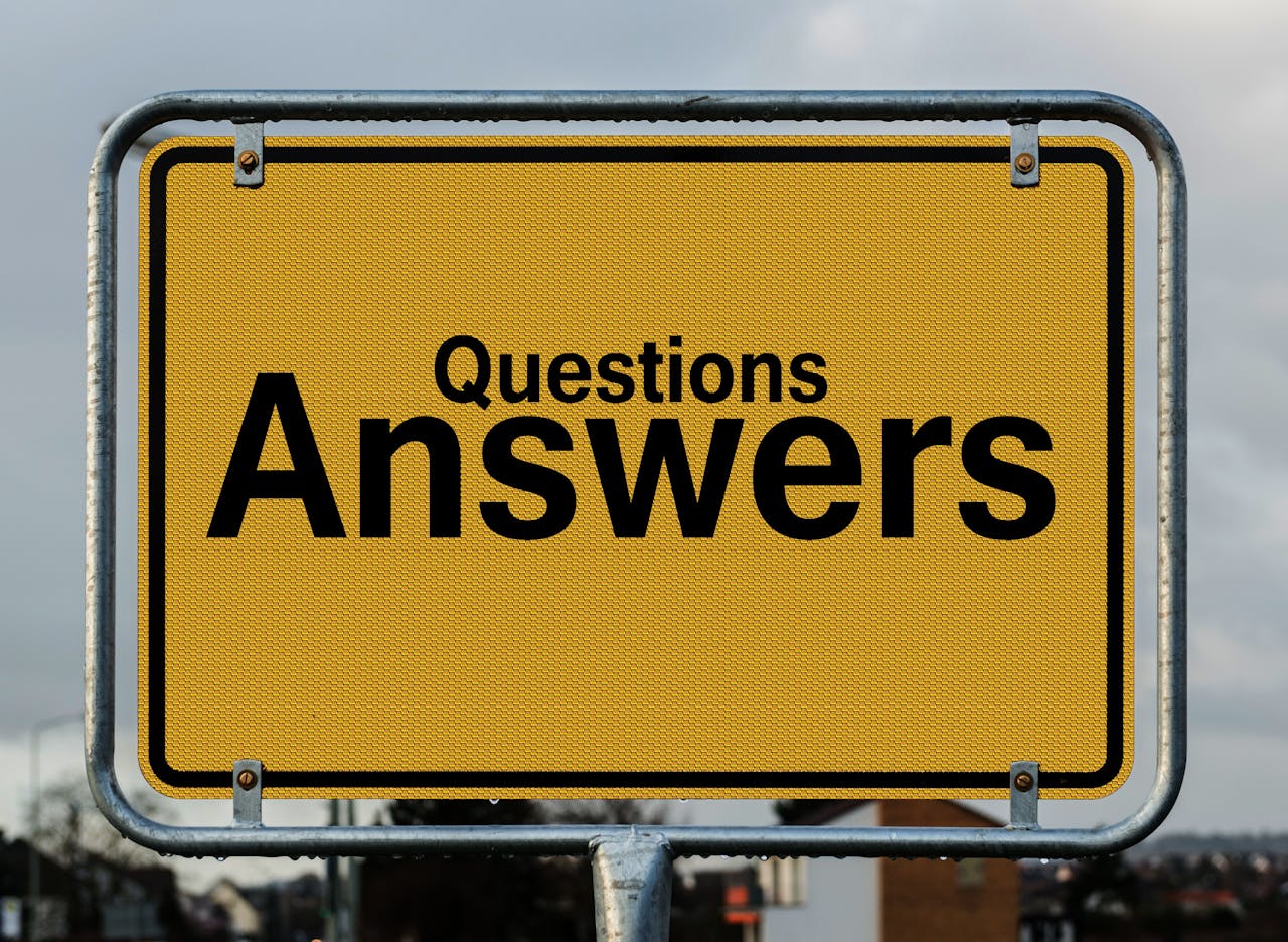 Yellow sign with black text “Questions Answers.” 