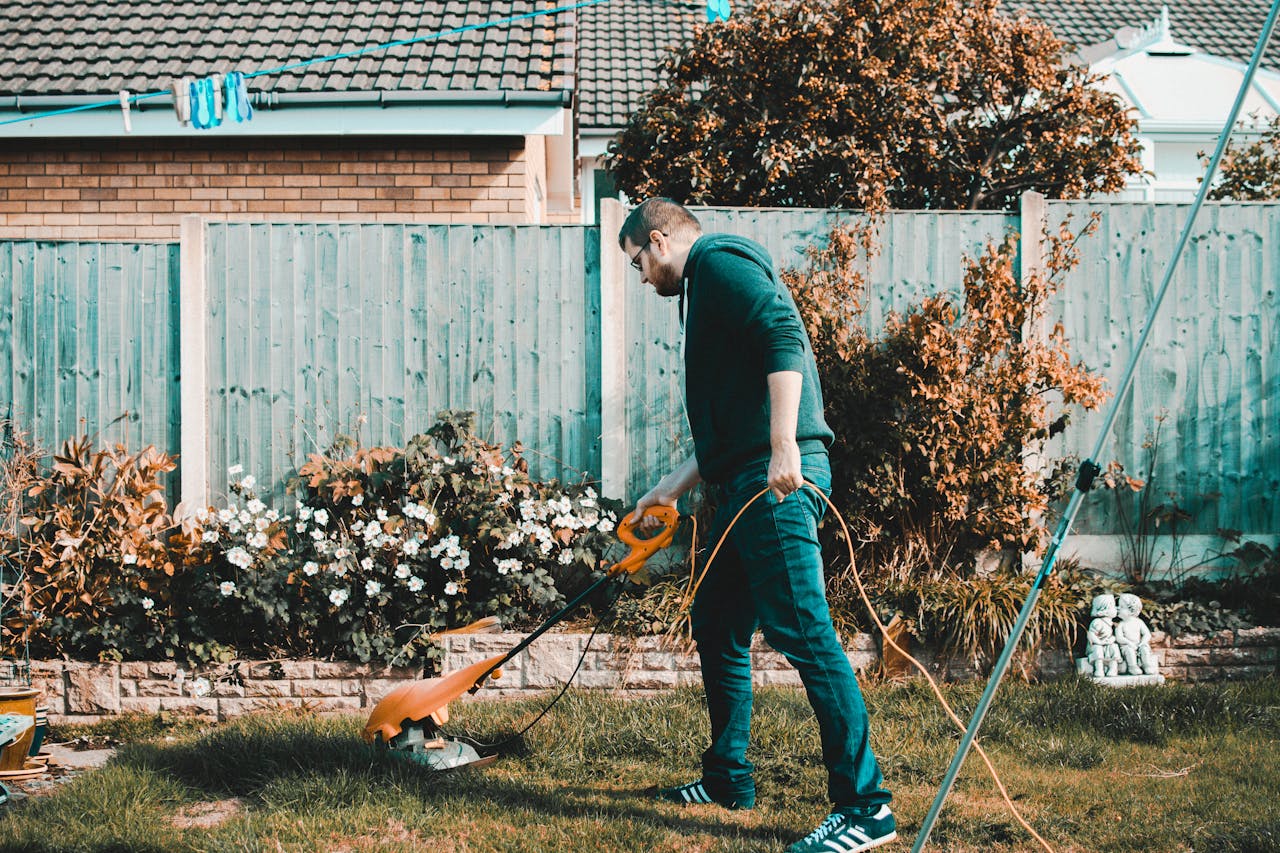 Man trimming lawn to show tasks related to spring home maintenance in Toronto.