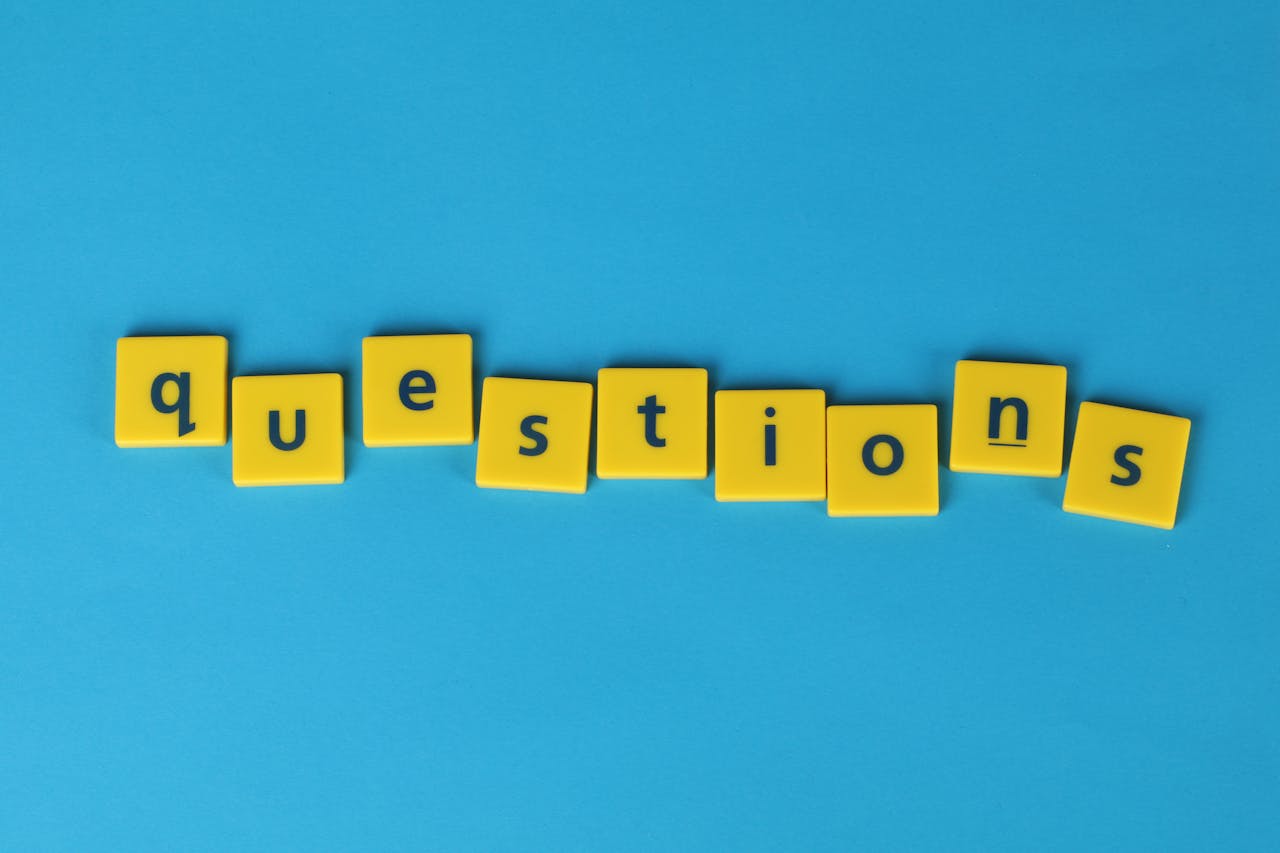 Yellow tiles spelling word "questions" on blue background to show FAQs section.